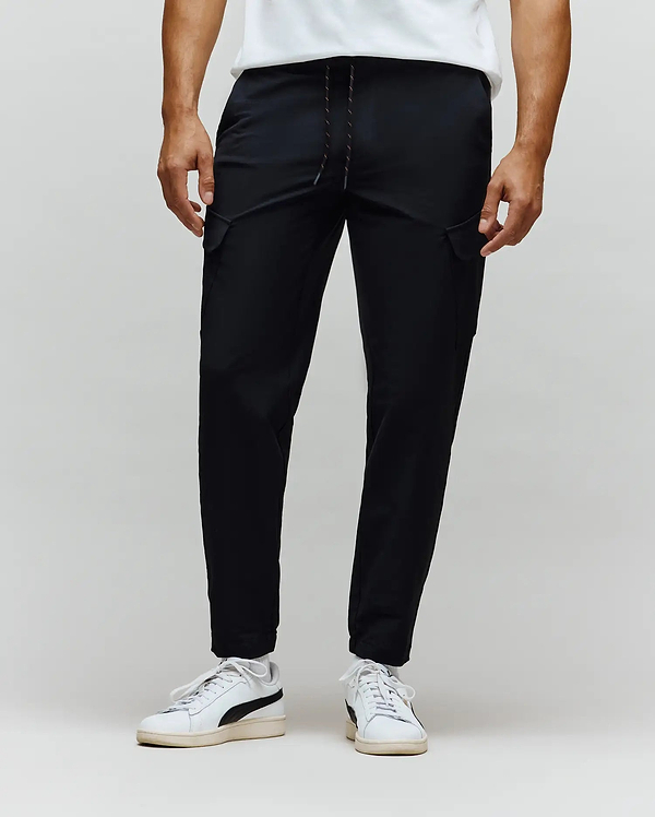 Mens Luka Cargo Pant in black, featuring a relaxed tapered fit, smooth fabric, drawstring waist with subtle multi-color flecks, and functional side cargo pockets.