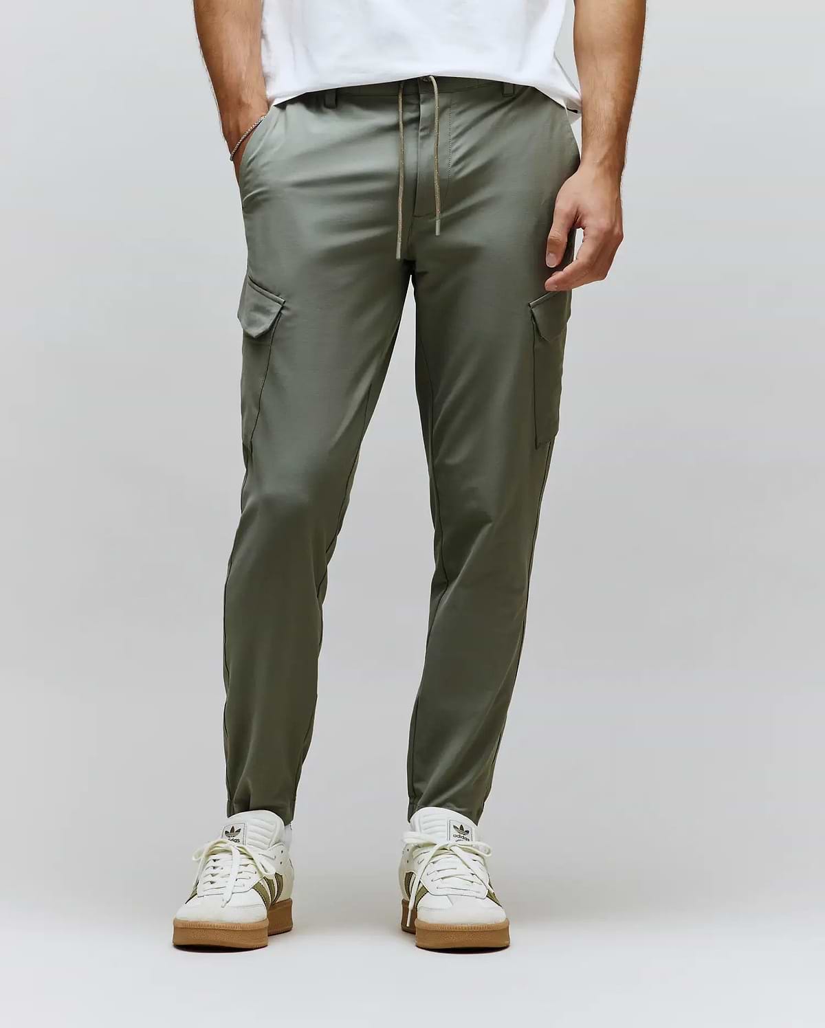 Olive green Luka Cargo Pant, smooth matte fabric, with side cargo pockets, a light brown drawstring waist, and a modern tapered fit. (1)