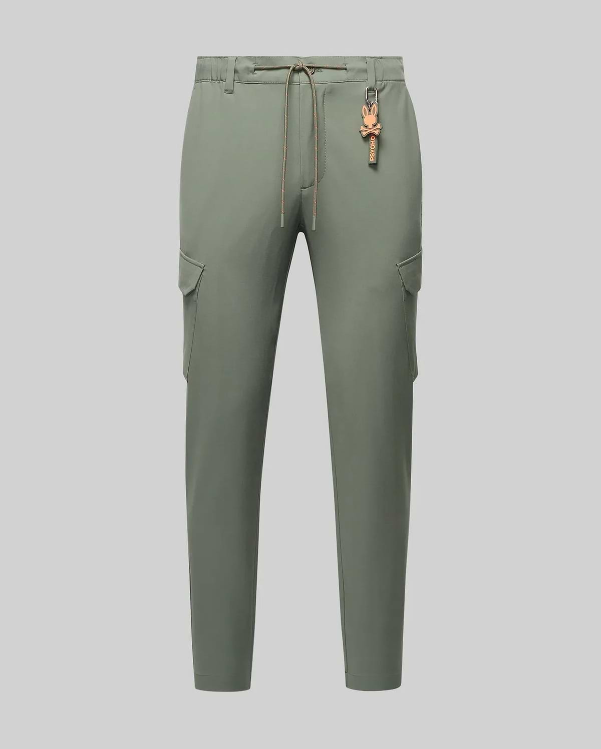 Mens Luka Cargo Pant in muted sage green, featuring a relaxed fit, smooth fabric, side cargo pockets, an orange drawstring waist, and a small orange Psycho Bunny skull keychain. (6)