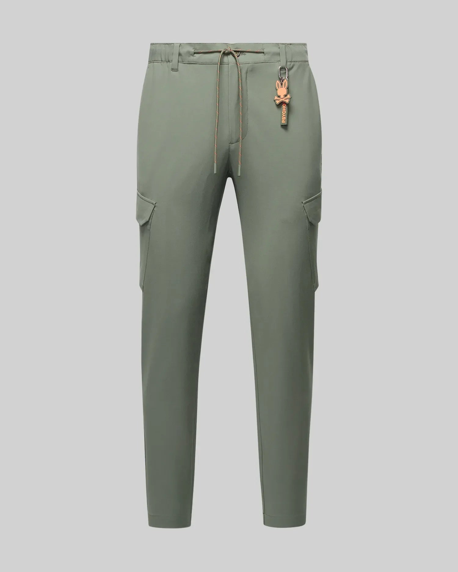 Mens Luka Cargo Pant in muted sage green, featuring a relaxed fit, smooth fabric, side cargo pockets, an orange drawstring waist, and a small orange Psycho Bunny skull keychain. (6)