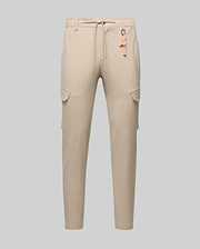 Mens Luka Cargo Pant in beige, featuring a relaxed fit, smooth fabric, side cargo pockets, and an elastic drawstring waist with an attached orange Psycho Bunny skull logo keychain.