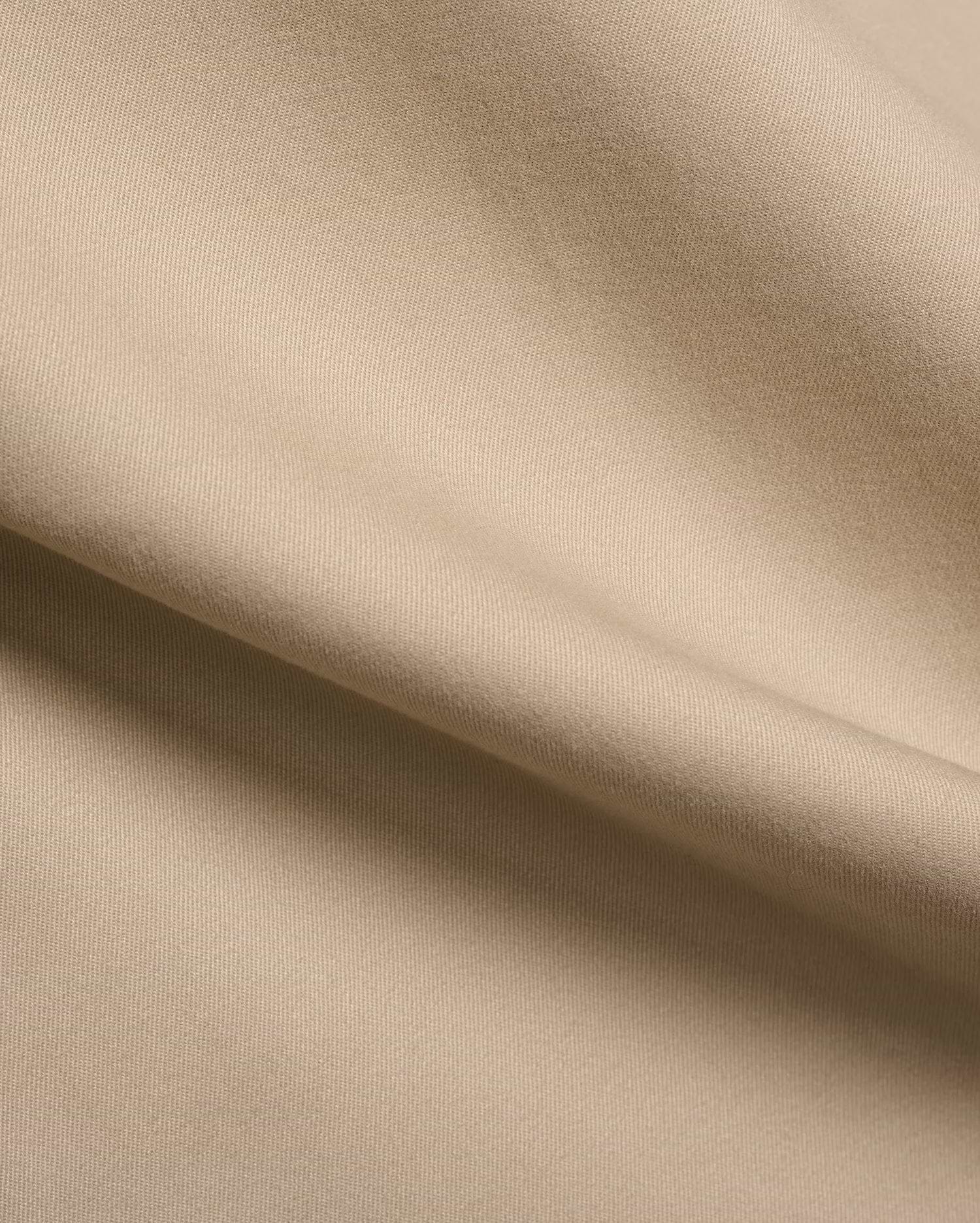 Mens Aidan Chino Pant in a warm khaki beige, featuring a refined, durable twill weave fabric with visible diagonal lines and a smooth, soft texture, draped in gentle folds.