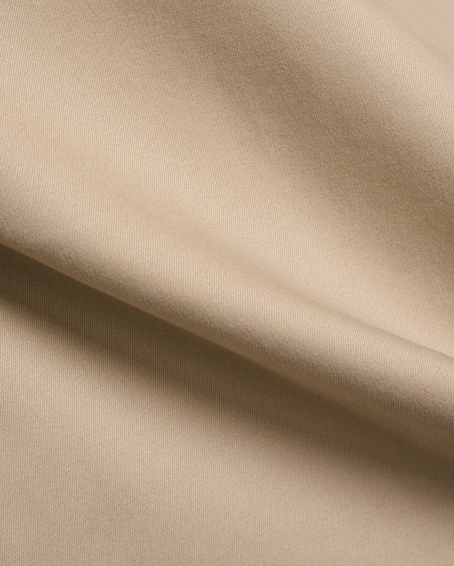 Mens Aidan Chino Pant in a warm khaki beige, featuring a refined, durable twill weave fabric with visible diagonal lines and a smooth, soft texture, draped in gentle folds.