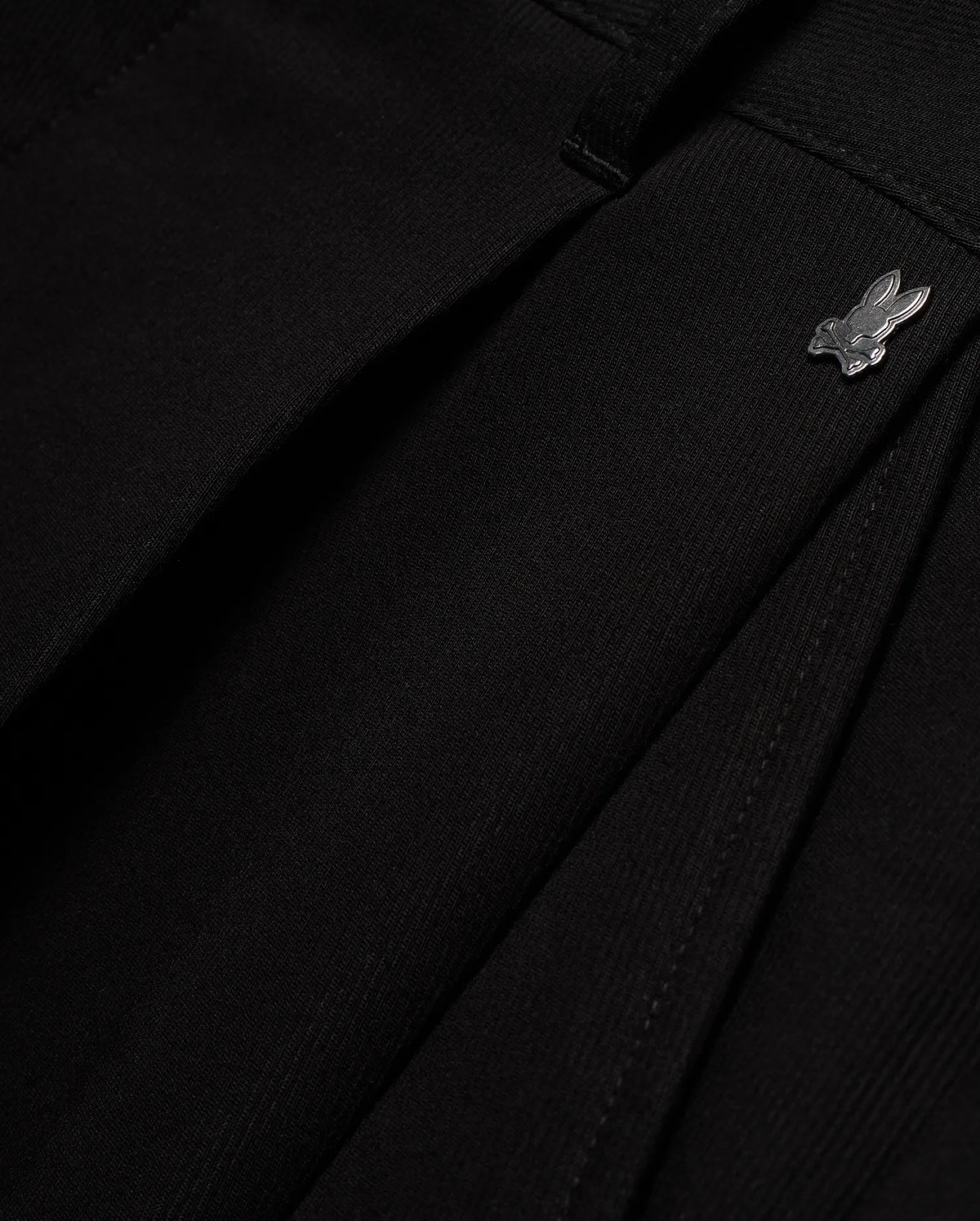 Men's Wayde Wide-Leg Pleated Pants in black, featuring a subtle fabric texture, wide-leg fit, and a small metallic silver Psycho Bunny skull logo near the waistband. (6)