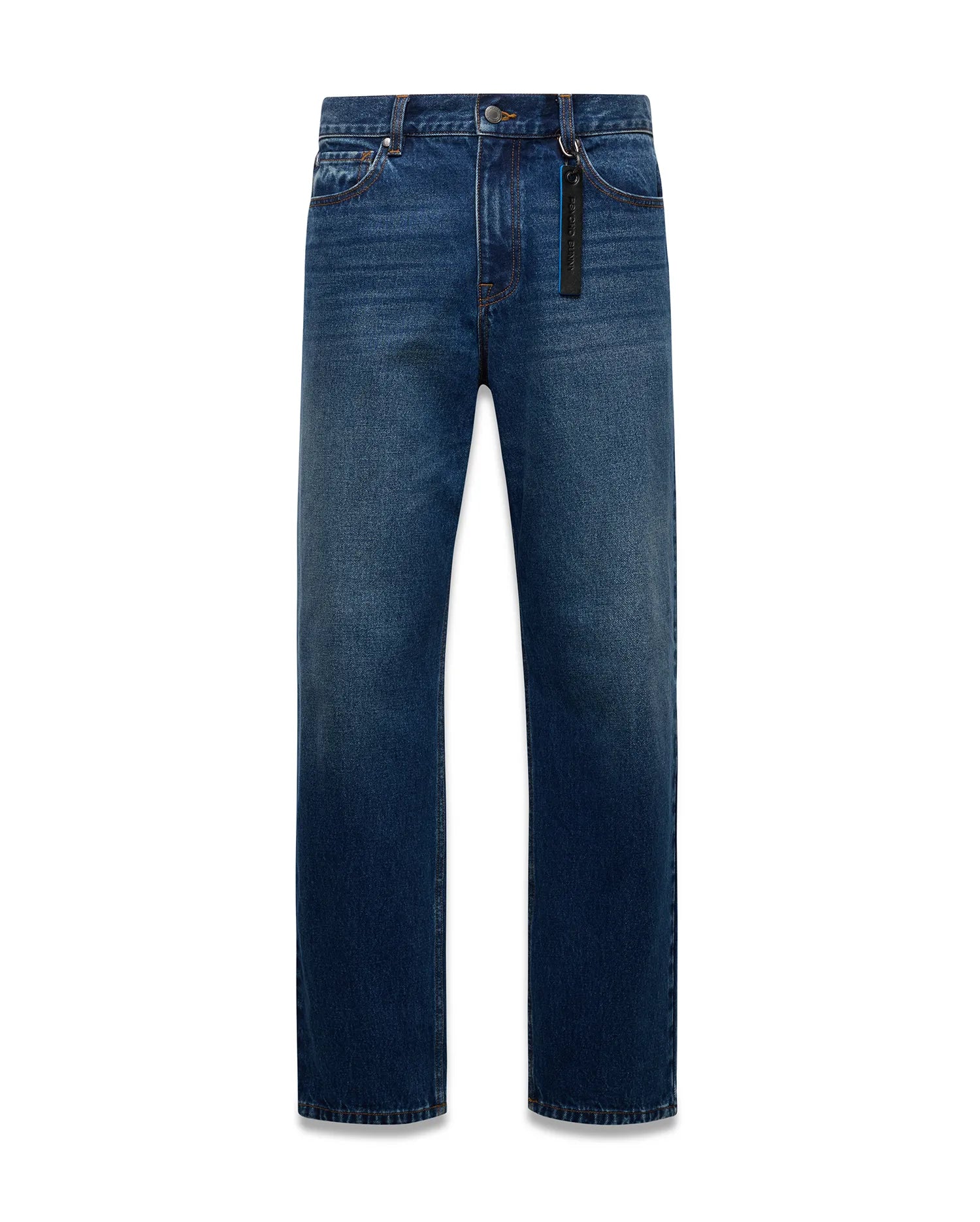 Mens Beck Denim Relaxed Pant in medium blue denim with a faded wash, orange contrast stitching, and a black Psycho Bunny branded tag with blue text on the front belt loop.