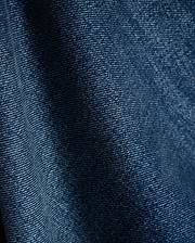 Mens Beck Denim Relaxed Pant in a rich, medium blue wash, showcasing a durable twill weave with subtle white thread accents and natural folds, creating a comfortable, lived-in texture.