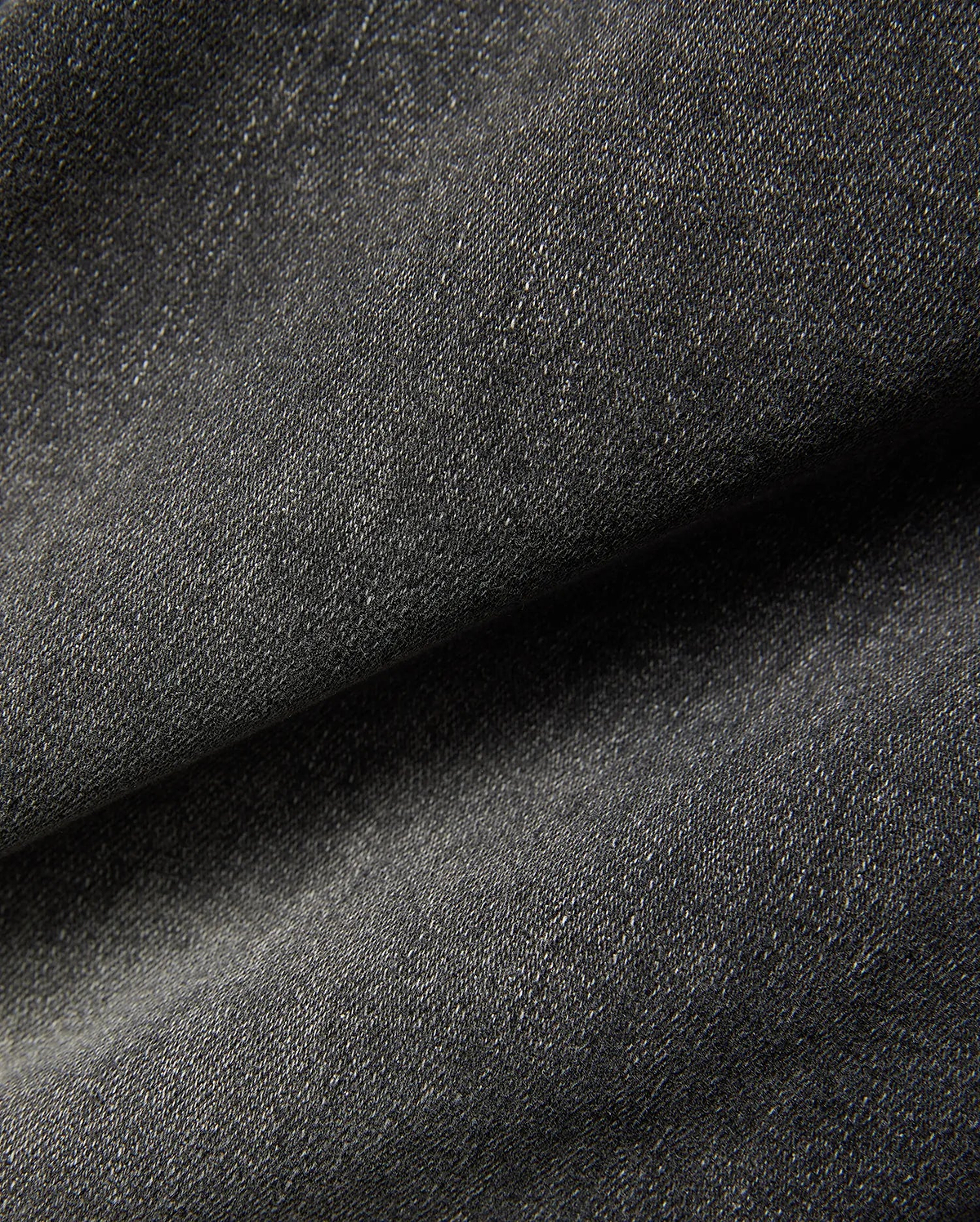 Mens Emerson Denim Pant featuring a dark charcoal grey denim fabric with a visible twill weave and subtle light flecks, creating a textured, washed appearance. (6)