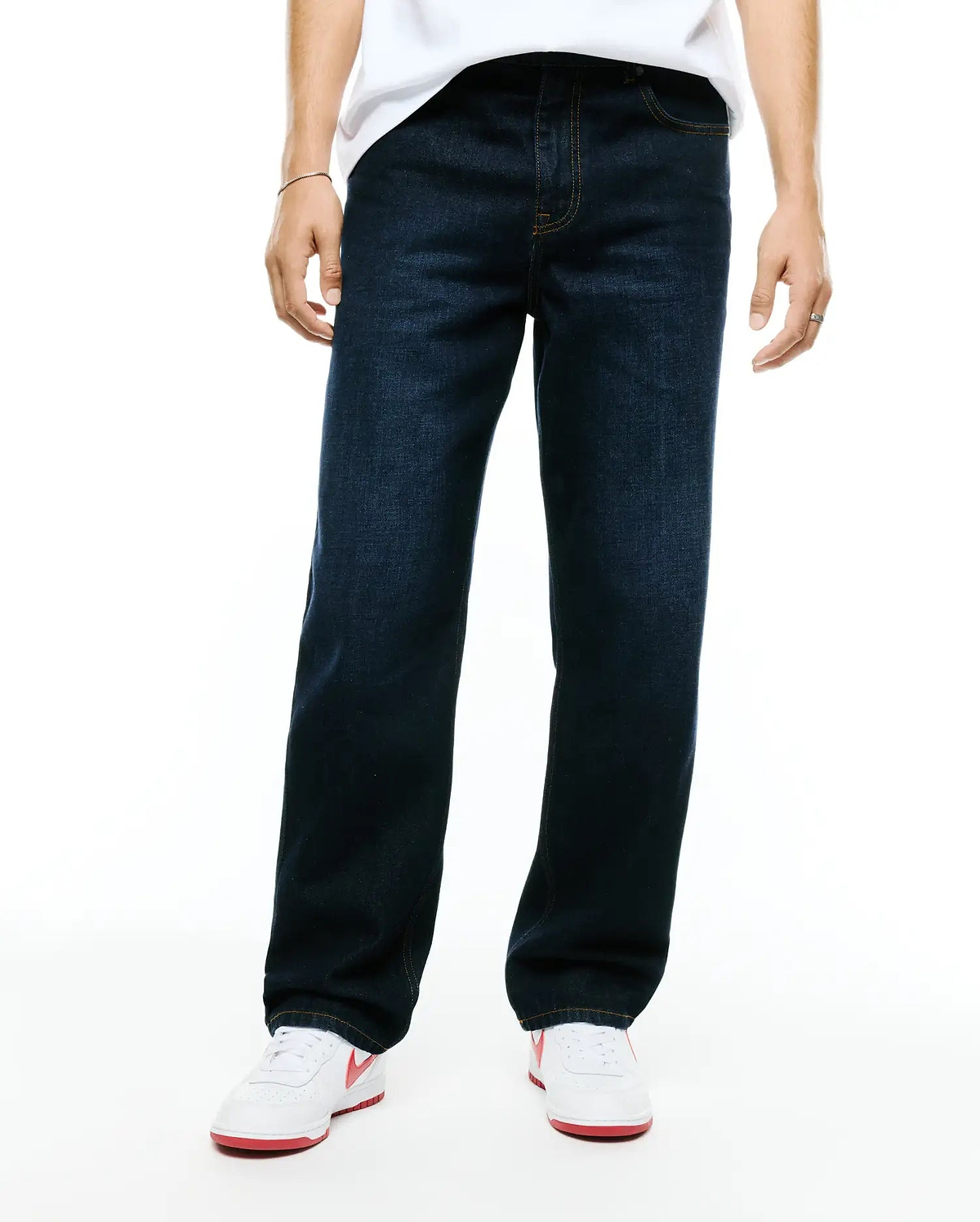 Men's Beck Oversized Denim Pants in dark indigo blue, featuring a relaxed straight leg fit, classic five-pocket styling, and contrasting orange stitching. (1)