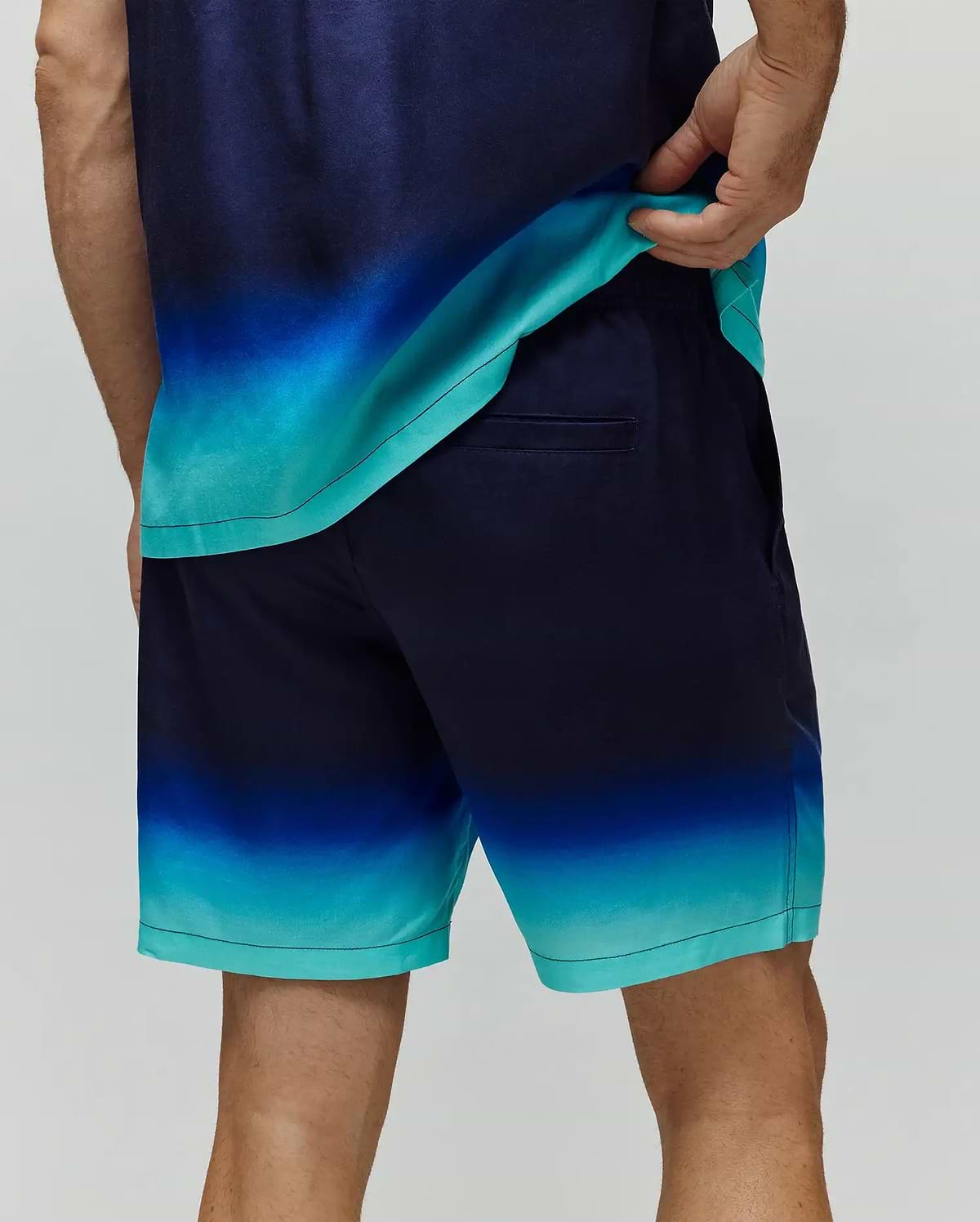 Mens Dax Tencel Short featuring a vibrant navy to blue to turquoise ombre pattern, smooth Tencel fabric, classic fit, and a discreet back welt pocket.