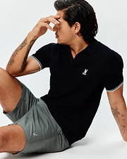 Black pique knit polo with white striped cuffs and an embroidered white Psycho Bunny logo on the chest, paired with Mens Ivan Linen Short in grey featuring a subtle embroidered grey Psycho Bunny logo on the leg.