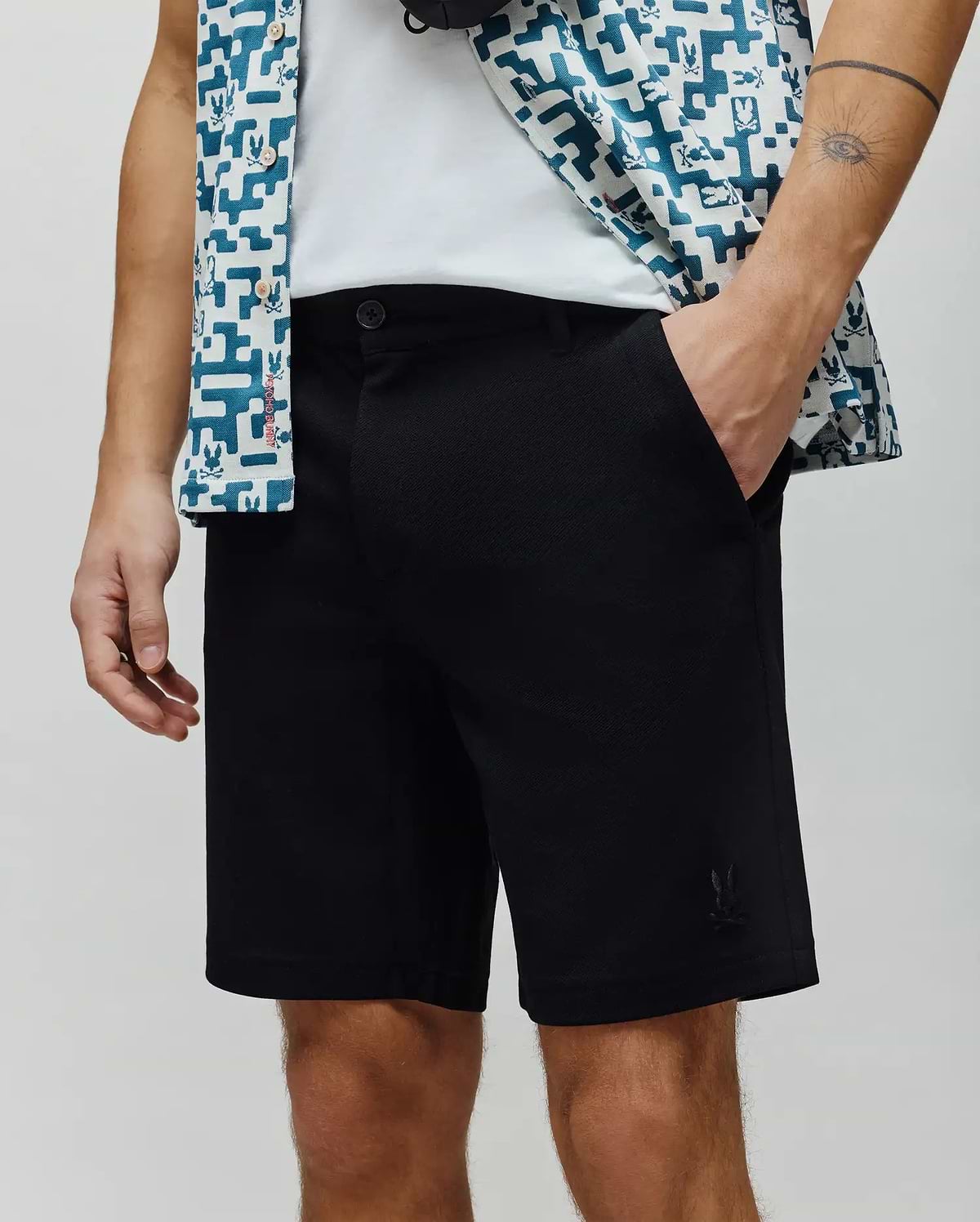Black mens shiro twill short, classic fit, subtle twill texture, featuring a small, tonal embroidered Psycho Bunny skull logo on the lower left leg. (2)