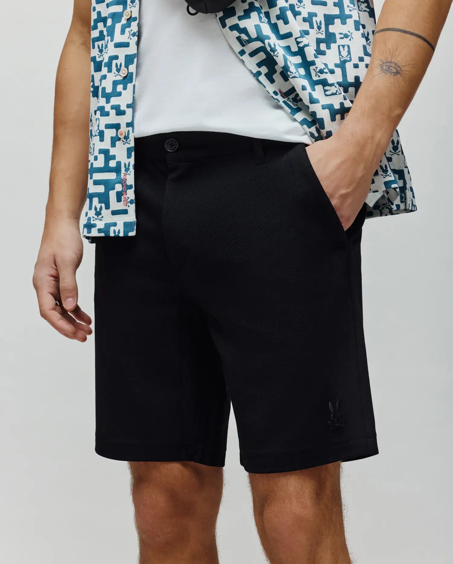 Black mens shiro twill short, classic fit, subtle twill texture, featuring a small, tonal embroidered Psycho Bunny skull logo on the lower left leg. (2)