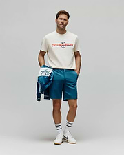 Classic fit cream jersey t-shirt featuring a large, colorful patterned Psycho Bunny logo, paired with Mens Shiro Twill Short in teal, and a matching teal bomber jacket with white Psycho script. (4)