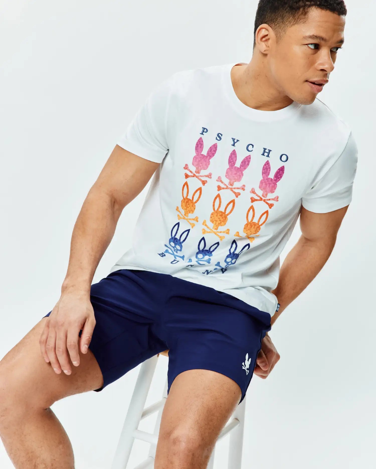 White classic fit jersey t-shirt with a large chest graphic of gradient PSYCHO text and multi-color bunny skull logos, paired with navy Mens Blaze Sport Short with a small white embroidered bunny skull logo on the left leg.