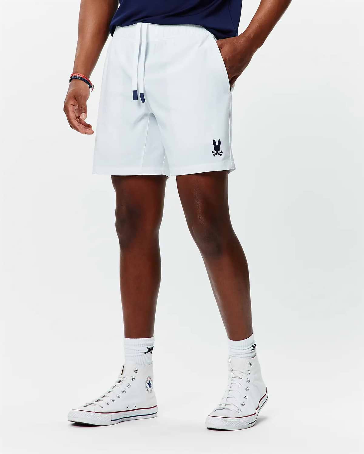 Mens Blaze Sport Short, white, relaxed fit, smooth performance fabric, featuring navy drawstring tips and a small embroidered navy Psycho Bunny skull logo on the lower left leg.