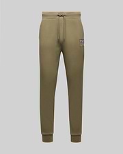 Psycho Bunny’s MENS WADE CORD PATCH SWEATPANT MB0800014 in olive green cotton blend features a drawstring waist, side pockets, rib knit cuffs, and a small “PSY E NYC” patch on the left thigh, shown on a light grey background.