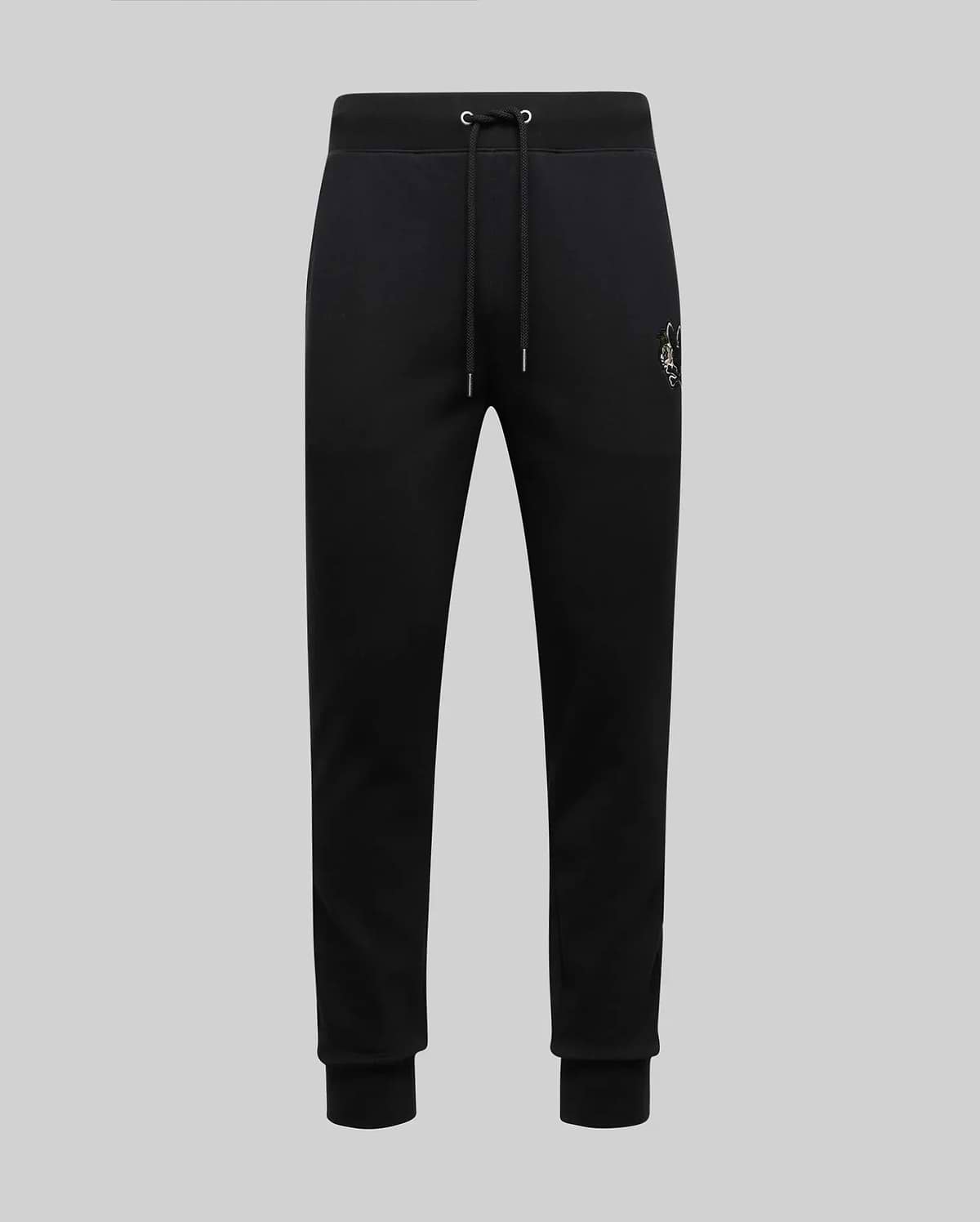 The Psycho Bunny MENS AUGUSTE JOGGER - MB0800015 are black 100% cotton joggers with a drawstring waist, ribbed cuffs, and a small embroidered crest on the left hip, shown against a plain light grey background.