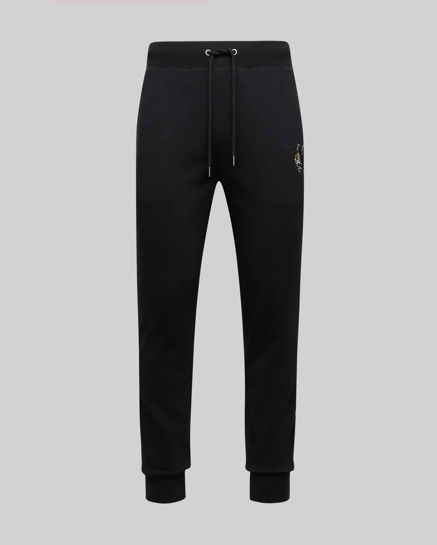 The Psycho Bunny MENS AUGUSTE JOGGER - MB0800015 are black 100% cotton joggers with a drawstring waist, ribbed cuffs, and a small embroidered crest on the left hip, shown against a plain light grey background.