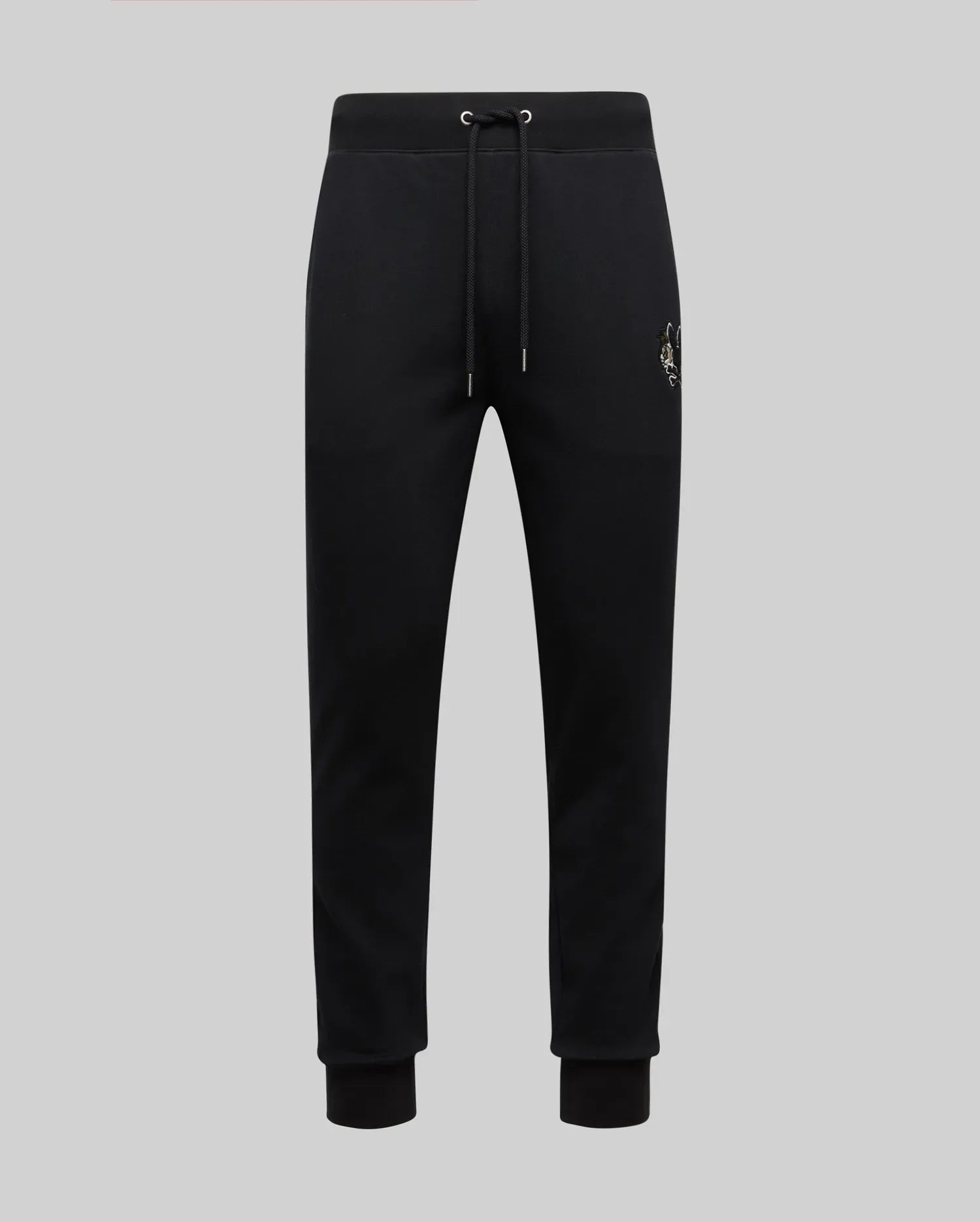 The Psycho Bunny MENS AUGUSTE JOGGER - MB0800015 are black 100% cotton joggers with a drawstring waist, ribbed cuffs, and a small embroidered crest on the left hip, shown against a plain light grey background.