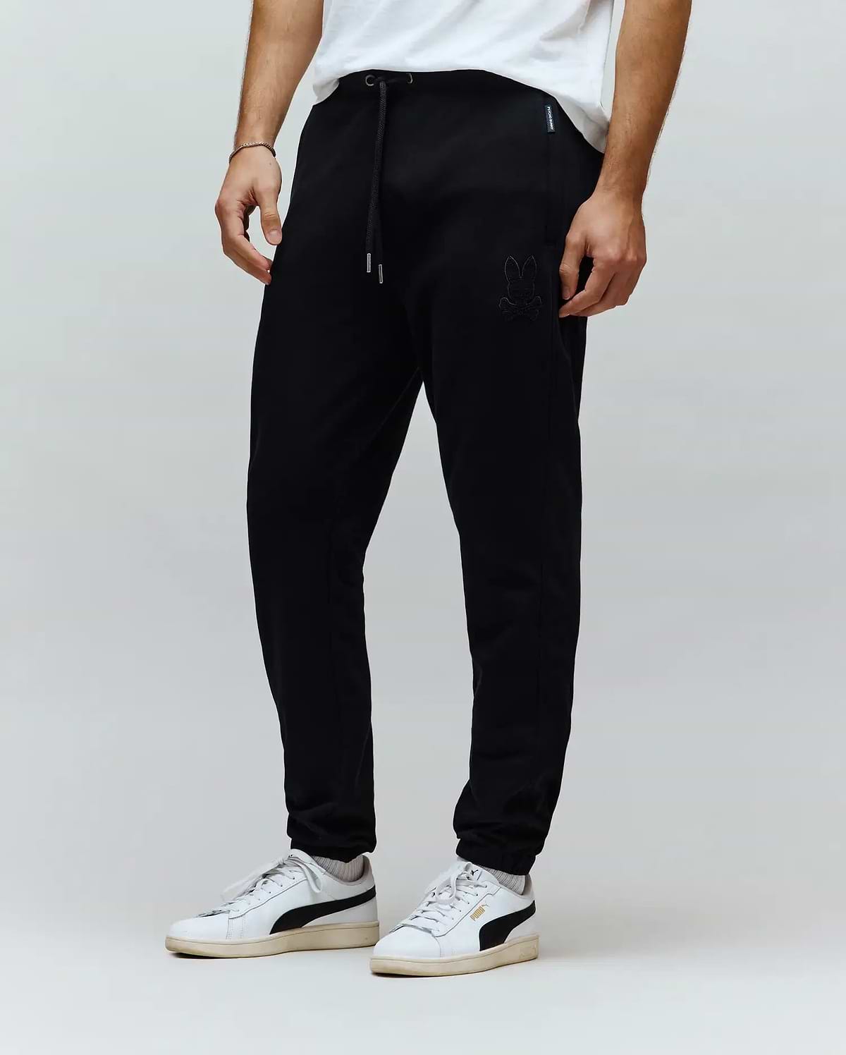 Black Mens Barry Joggers in a relaxed, tapered fit, crafted from soft jersey knit fabric. Features a tonal embroidered Psycho Bunny skull logo on the left thigh and a drawstring waist with silver tips.