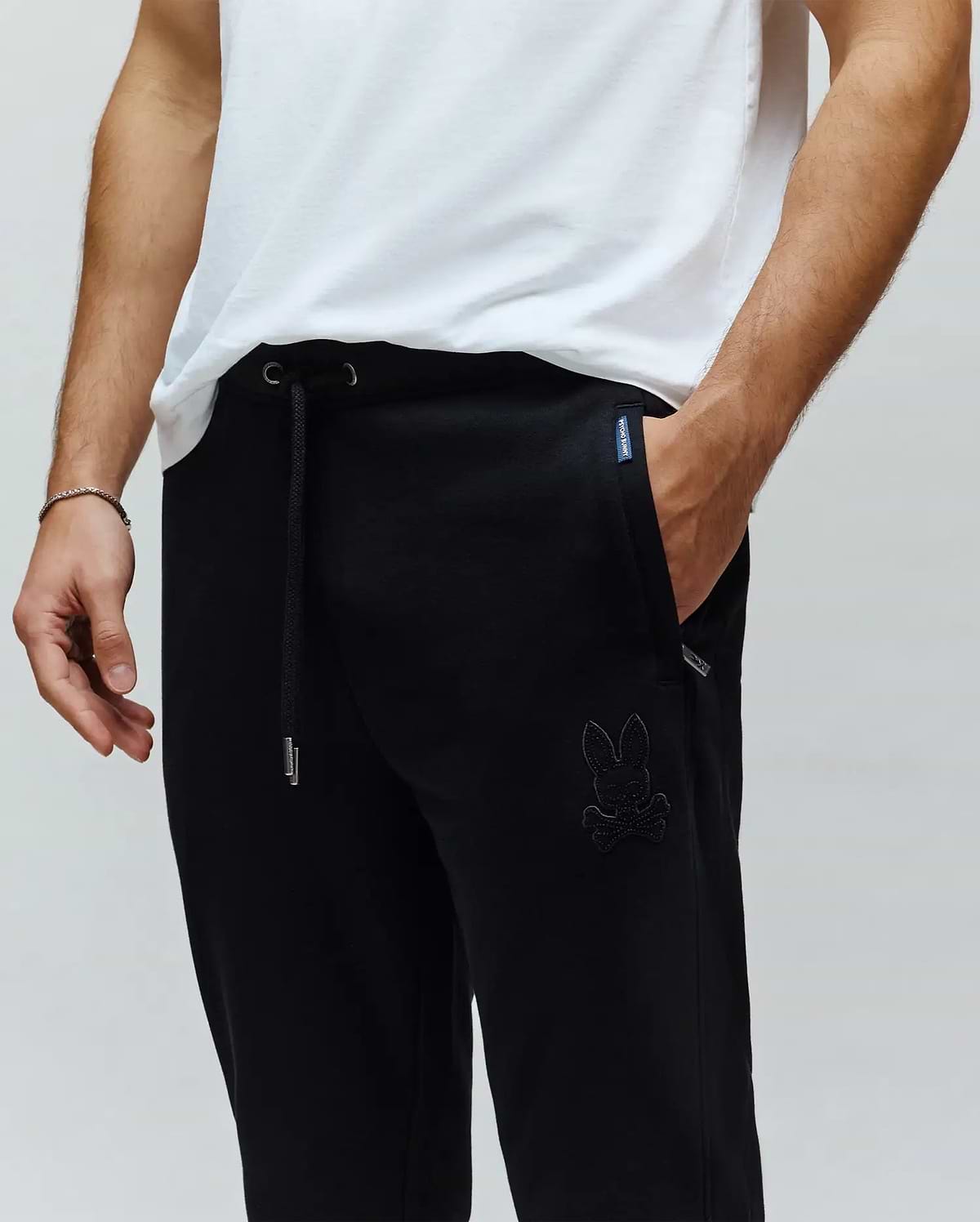 Black Mens Barry Joggers, relaxed fit, smooth jersey fabric, featuring a drawstring waist with silver tips, and a large tonal embroidered Psycho Bunny skull logo on the left thigh.