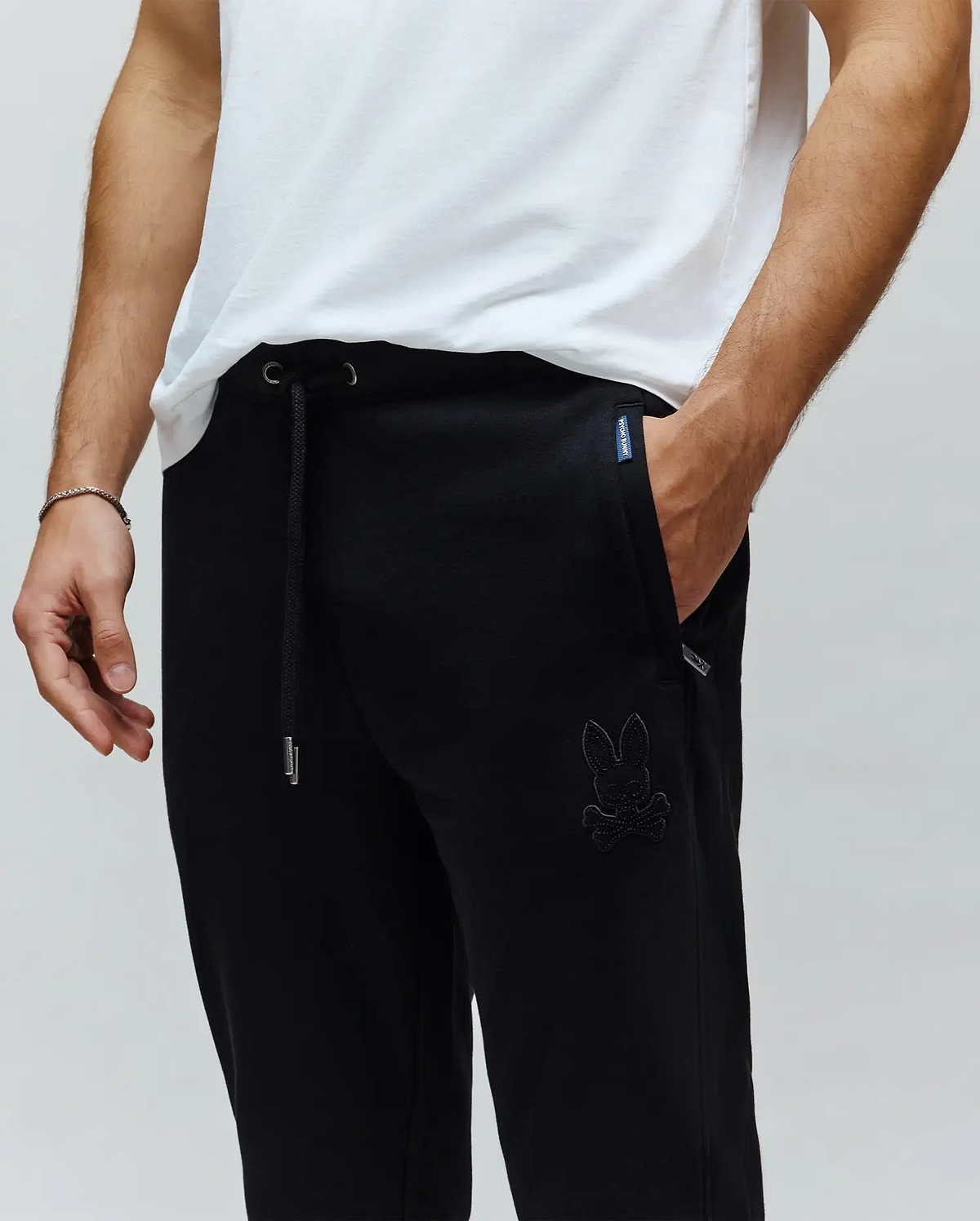 Black Mens Barry Joggers, relaxed fit, smooth jersey fabric, featuring a drawstring waist with silver tips, and a large tonal embroidered Psycho Bunny skull logo on the left thigh.