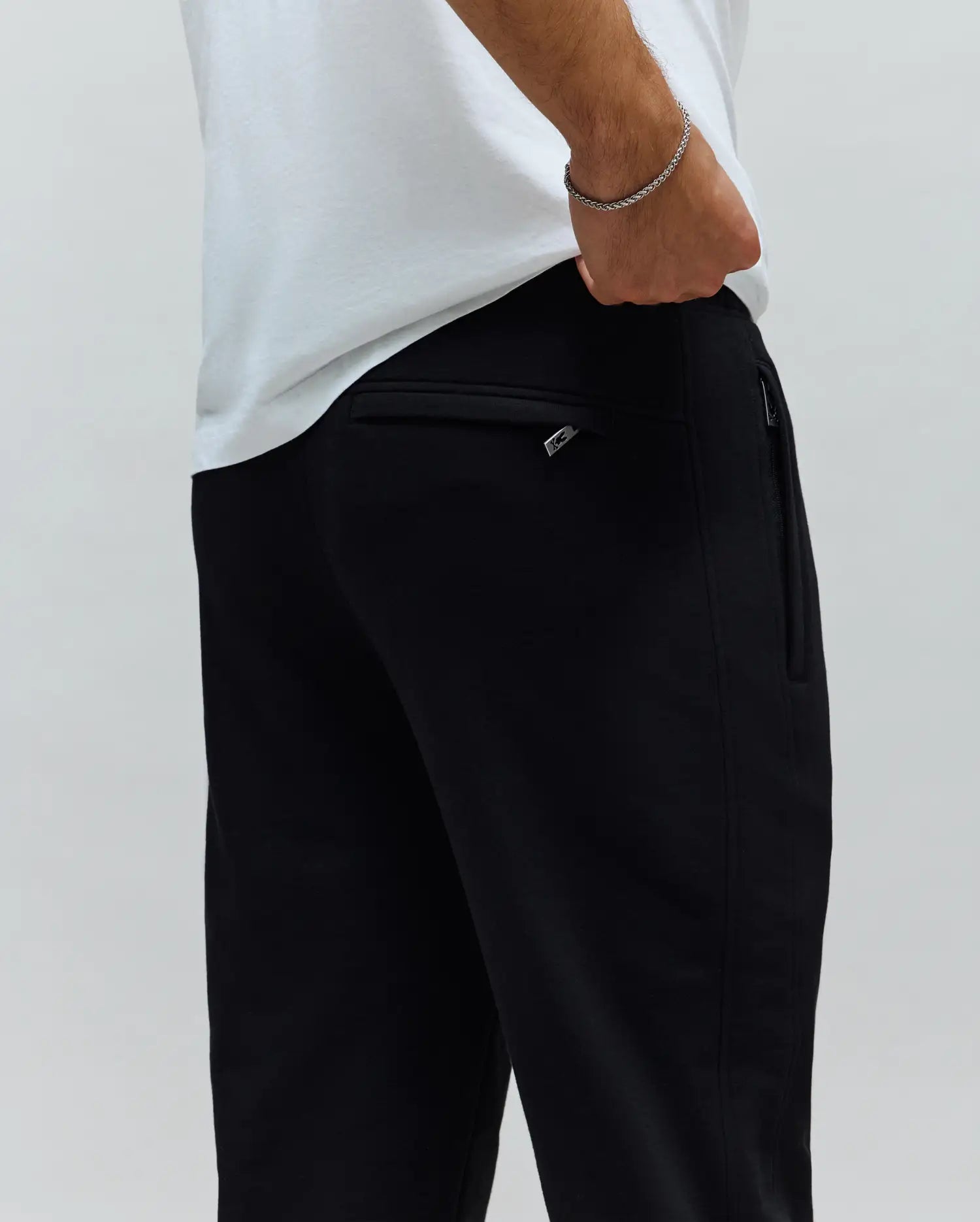 Mens Barry Joggers, black, relaxed fit, crafted from smooth knit fabric. Features a rear welt pocket and a side zipper pocket with a small silver Psycho Bunny logo pull.