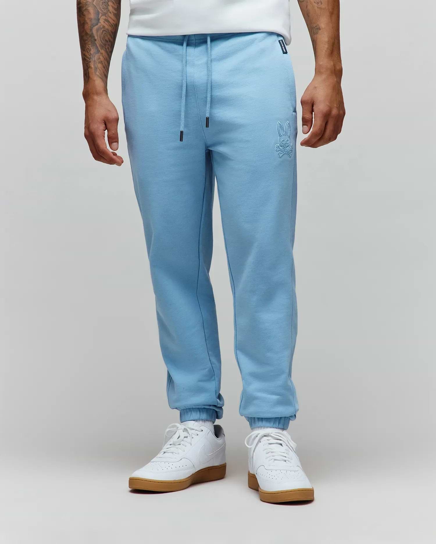 Mens Barry Joggers in light blue, featuring a relaxed fit and soft french terry fabric. Tonal embroidered Psycho Bunny skull logo on the left thigh, drawstring waist with black tips, and ribbed cuffs. (1)