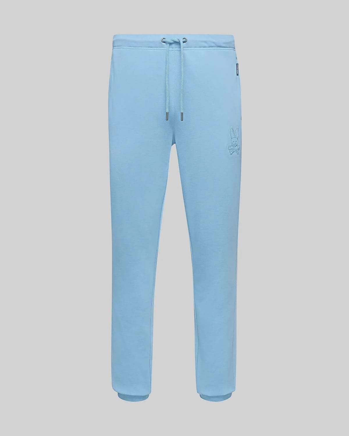 Mens Barry Joggers in light blue, featuring a relaxed fit, soft jersey fabric, drawstring waist, ribbed cuffs, and a small embroidered Psycho Bunny skull logo on the left thigh. (5)