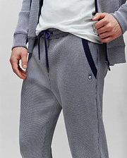 Mens Maxton Two Tone Jogger in a navy and white micro-patterned knit, featuring a classic fit, navy side stripe, drawstrings, and a small embroidered Psycho Bunny skull logo on the left thigh.