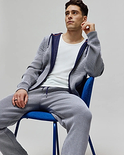 Mens Maxton Two Tone Jogger and matching full-zip hoodie in a white and navy micro-textured knit, featuring a small embroidered Psycho Bunny skull logo on the chest, navy drawstrings, and orange accent trim, offering a relaxed fit.