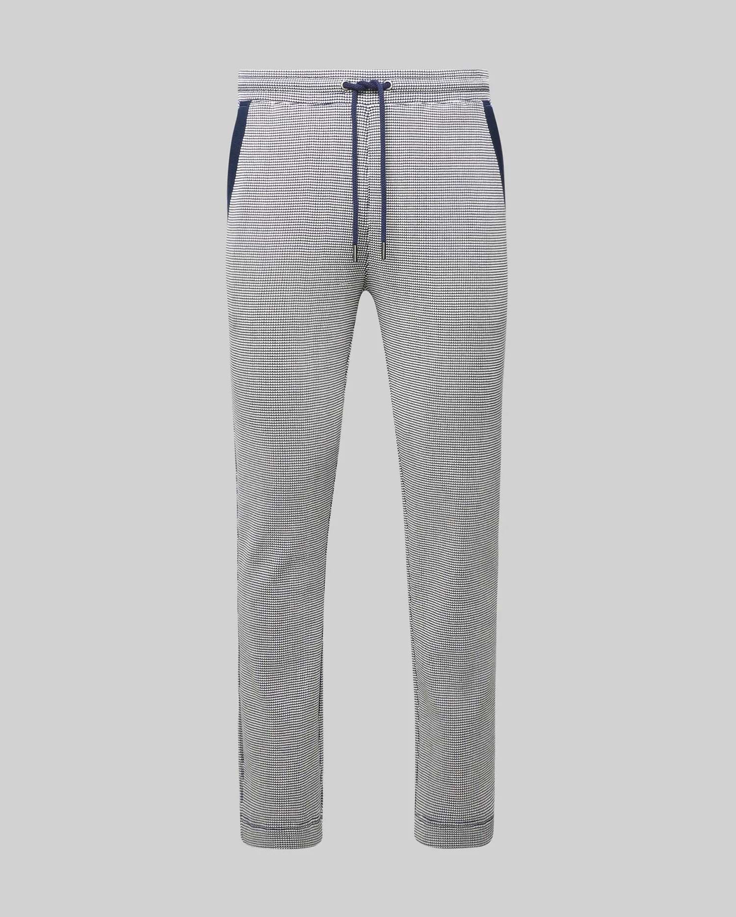 Mens Maxton Two Tone Jogger, a slim fit jogger in a white and black micro-patterned textured knit, featuring a navy blue drawstring, waistband, and side pocket trim.