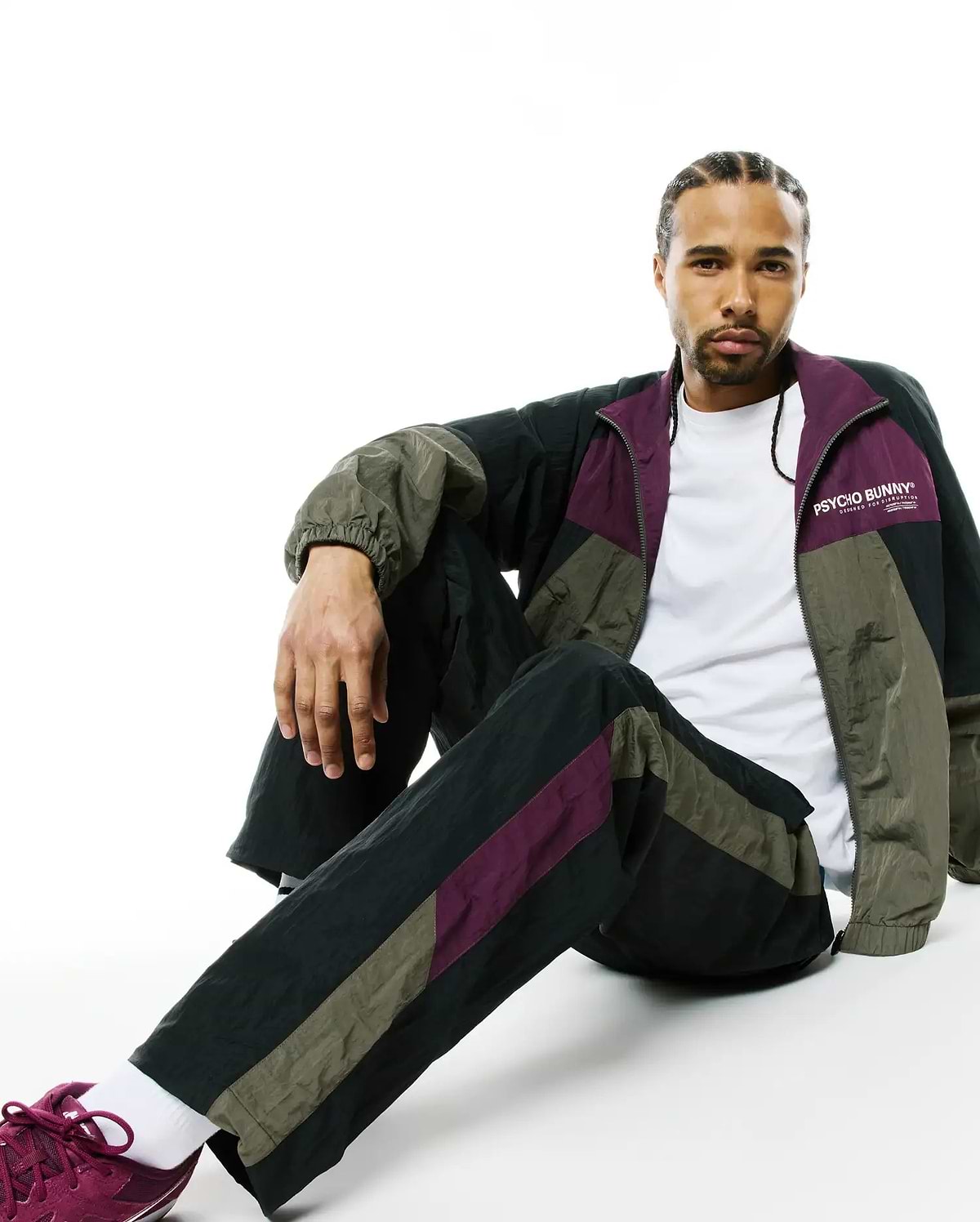 Mens Alder Nylon Colorblock Pant and matching relaxed-fit full-zip track jacket in black, olive green, and deep purple crinkled nylon, with a white Psycho Bunny chest logo.