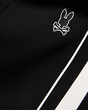 Mens Ceano Track Pant in black smooth knit fabric, featuring a small embroidered white outline Psycho Bunny skull logo and a bold white side stripe with piping.