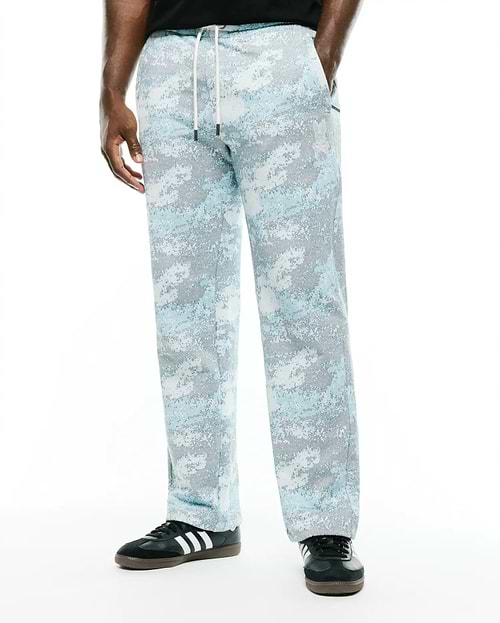 Men's Alfie Graphic Sweatpants in light blue, grey, and white digital camouflage pattern, featuring a relaxed straight leg fit, white drawstring, and small embroidered Psycho Bunny skull logo on the left thigh. (2)