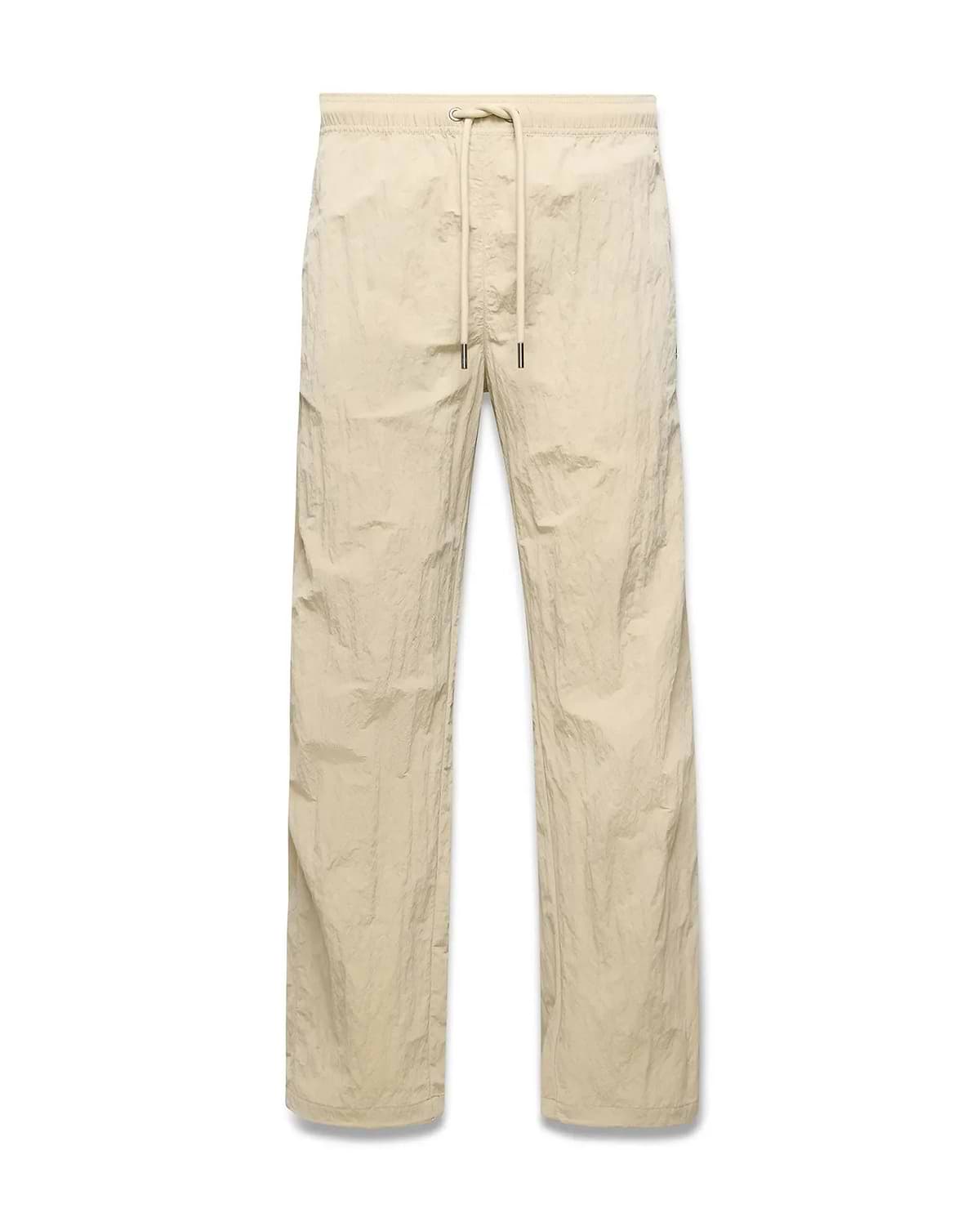 Mens Alder Nylon Pant in light beige with a crinkled nylon texture, featuring a relaxed straight-leg fit and an elasticated drawstring waist. (5)