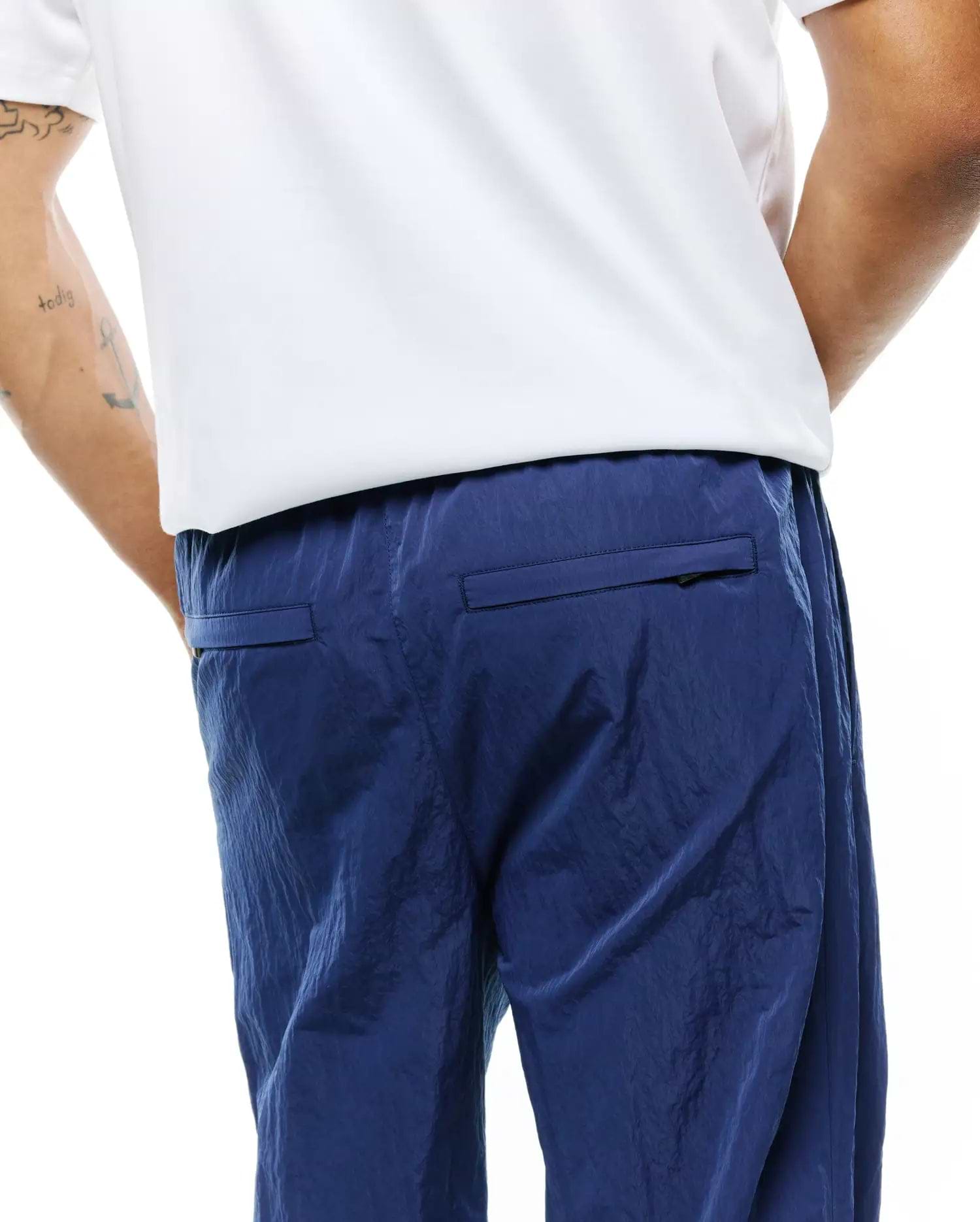 MENS ALDER NYLON PANT in deep navy blue, showcasing a distinctive crinkled nylon fabric texture, a comfortable relaxed fit, and practical rear flap pockets. (2)