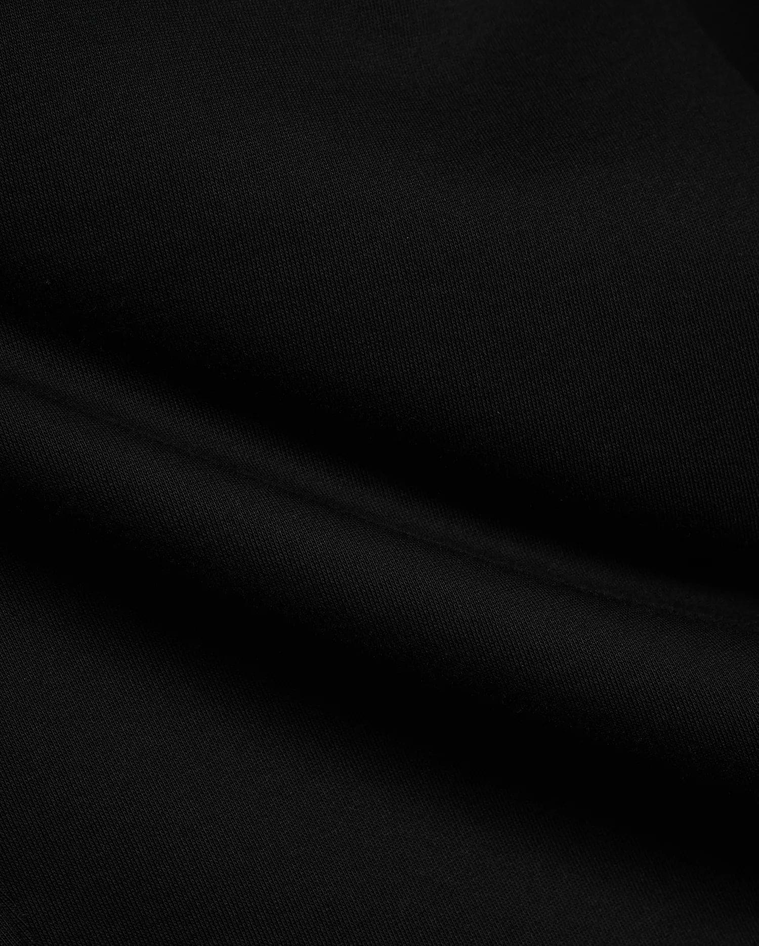 Black Mens Terrence Brushed Fleece Sweatpant fabric, showcasing the soft, luxurious texture of premium brushed fleece material with subtle, comfortable folds, ideal for refined streetwear.