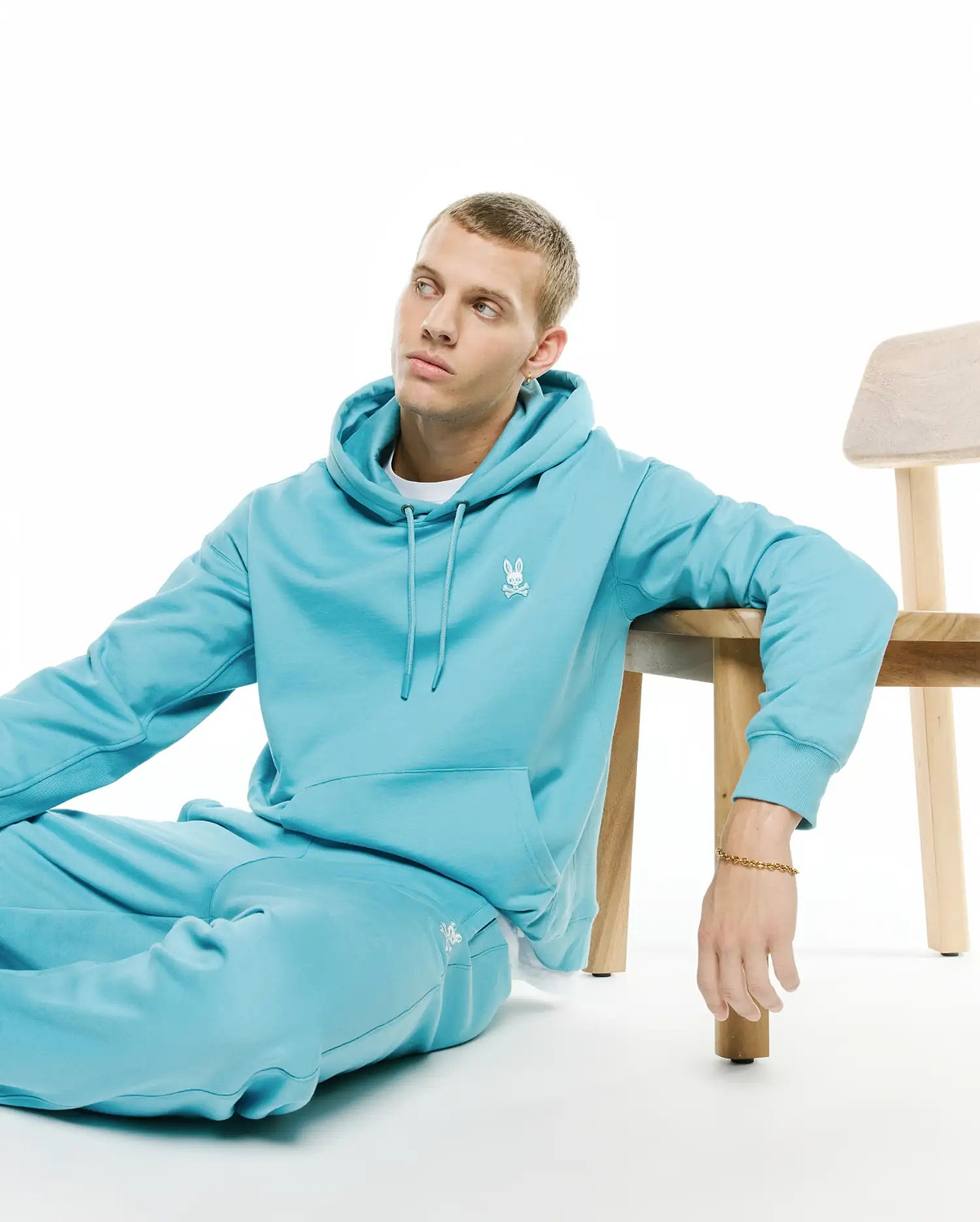 Relaxed aqua brushed fleece hoodie with drawstring, kangaroo pocket, and small white embroidered Psycho Bunny skull logo on left chest, matching Mens Terrence Brushed Fleece Jogger with logo on left thigh. (4)