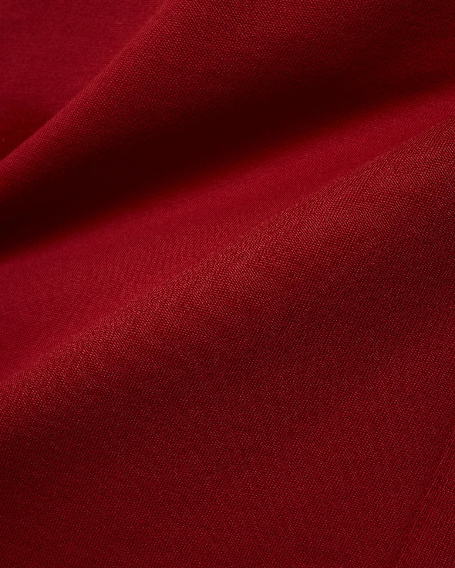 Mens Terrence Brushed Fleece Jogger in a deep, luxurious burgundy red, a close-up revealing the soft, plush texture of the brushed fleece fabric with subtle diagonal knit details. (6)