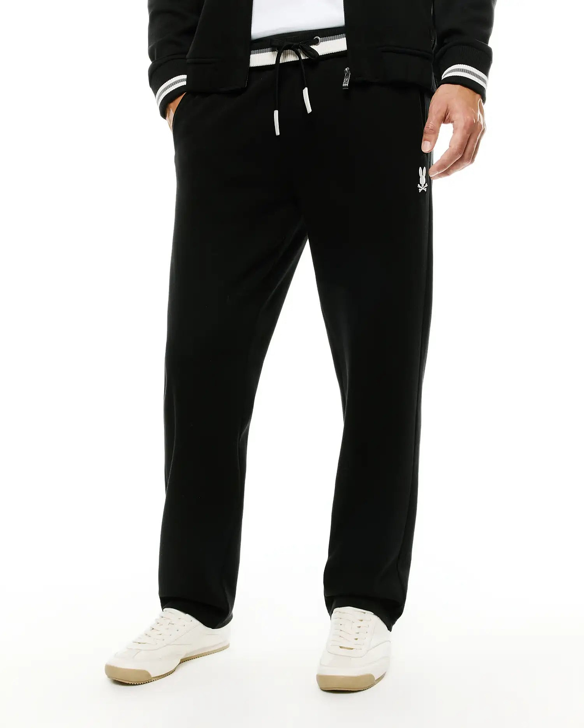 Men's Jacques Pique Track Pants in black, offering a relaxed fit with a white drawstring waist, subtle pique texture, and a small white embroidered Psycho Bunny skull logo on the right thigh. (2)