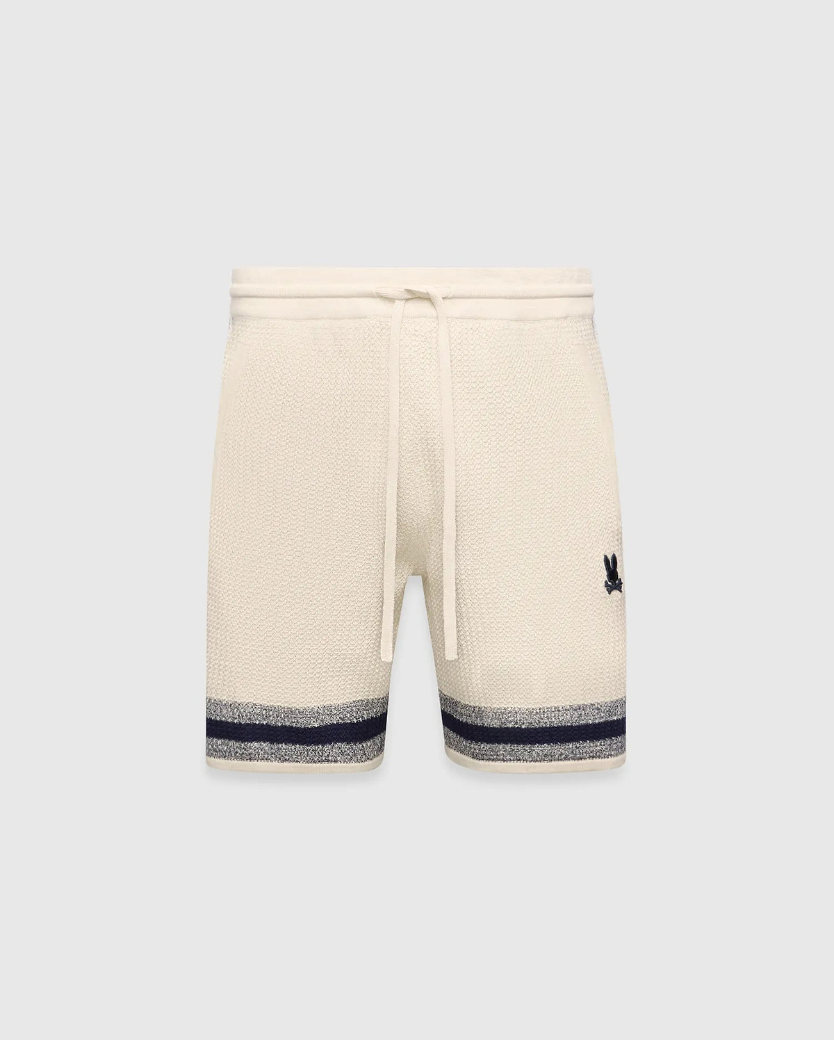 Mens Giles Knit Short 7 in cream, featuring a textured knit, drawstring waist, embroidered navy Psycho Bunny logo on the right thigh, and a navy and grey striped hem.