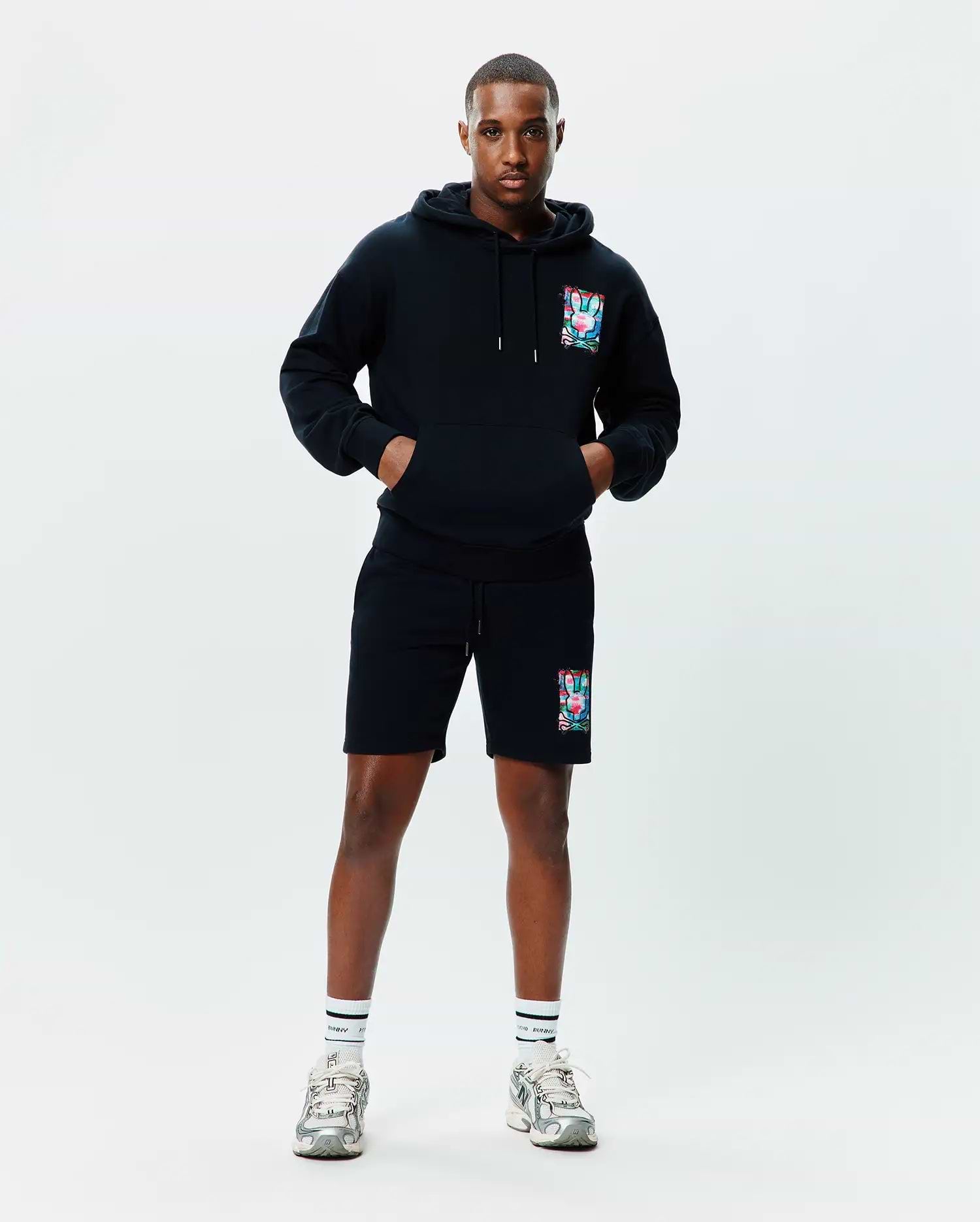 Black relaxed fit French terry hoodie with a large colorful abstract bunny skull graphic on the left chest, paired with matching Mens Isaac Print Short with the same graphic on the left thigh.