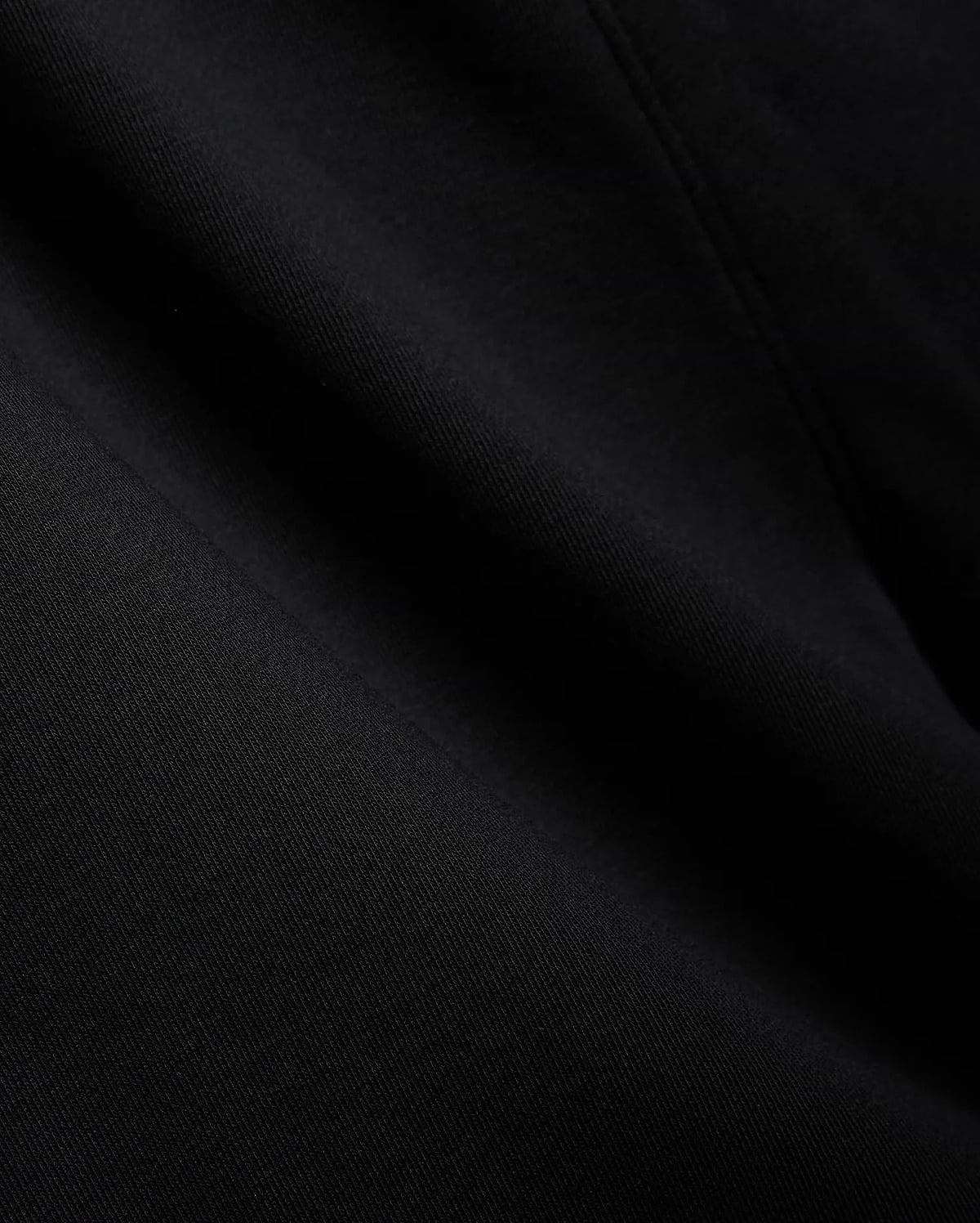 Mens Isaac Print Short in deep black, showcasing a premium, soft jersey knit fabric with a subtle, refined texture and gentle folds, embodying Psycho Bunny's quality.