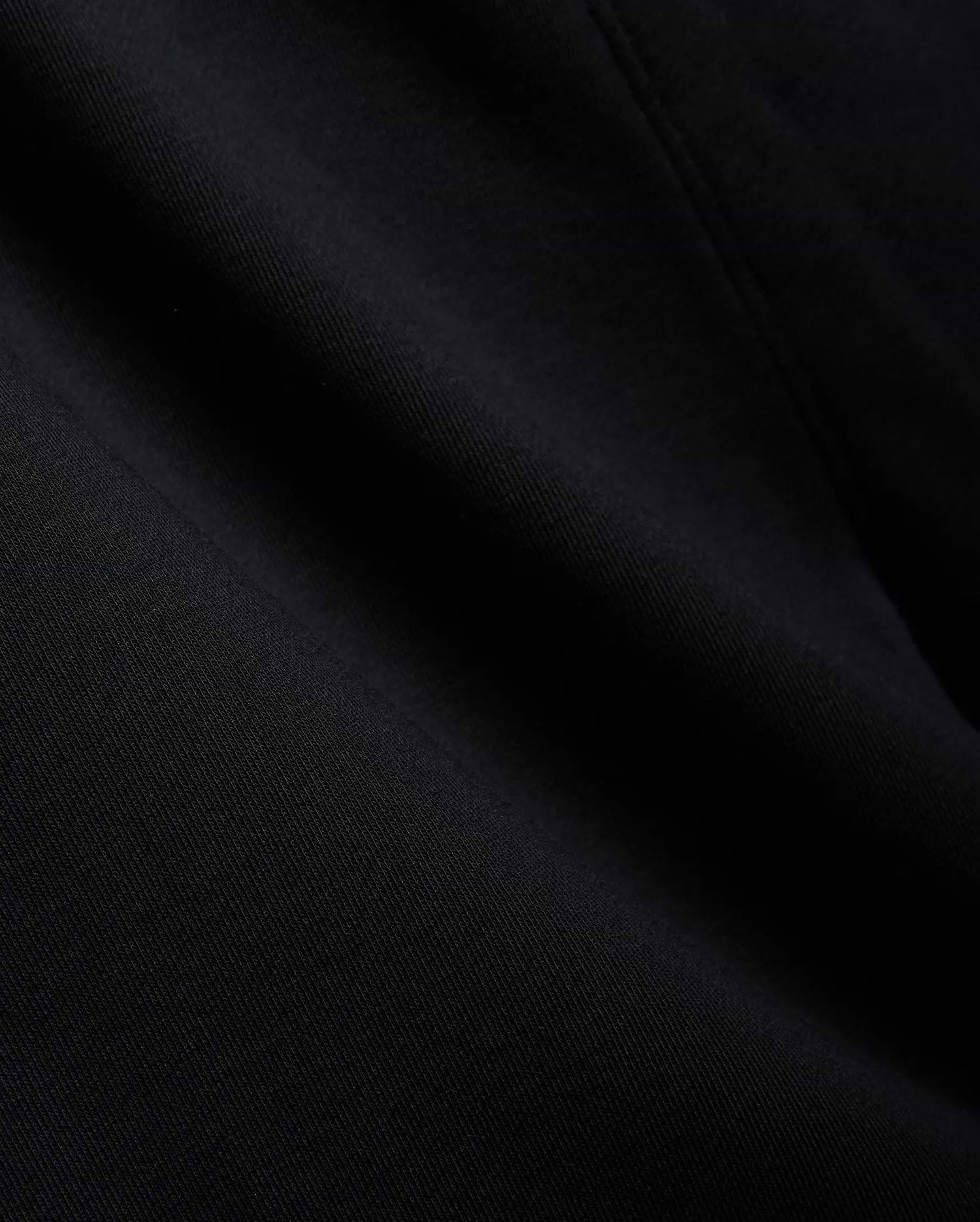 Mens Isaac Print Short in deep black, showcasing a premium, soft jersey knit fabric with a subtle, refined texture and gentle folds, embodying Psycho Bunny's quality.