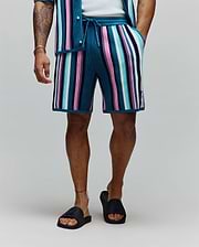 Mens Cliff Knit Short, relaxed fit, vibrant multi-color vertical stripes in teal, pink, light blue, white, and navy ribbed knit, with a small embroidered Psycho Bunny skull logo on the lower left leg.