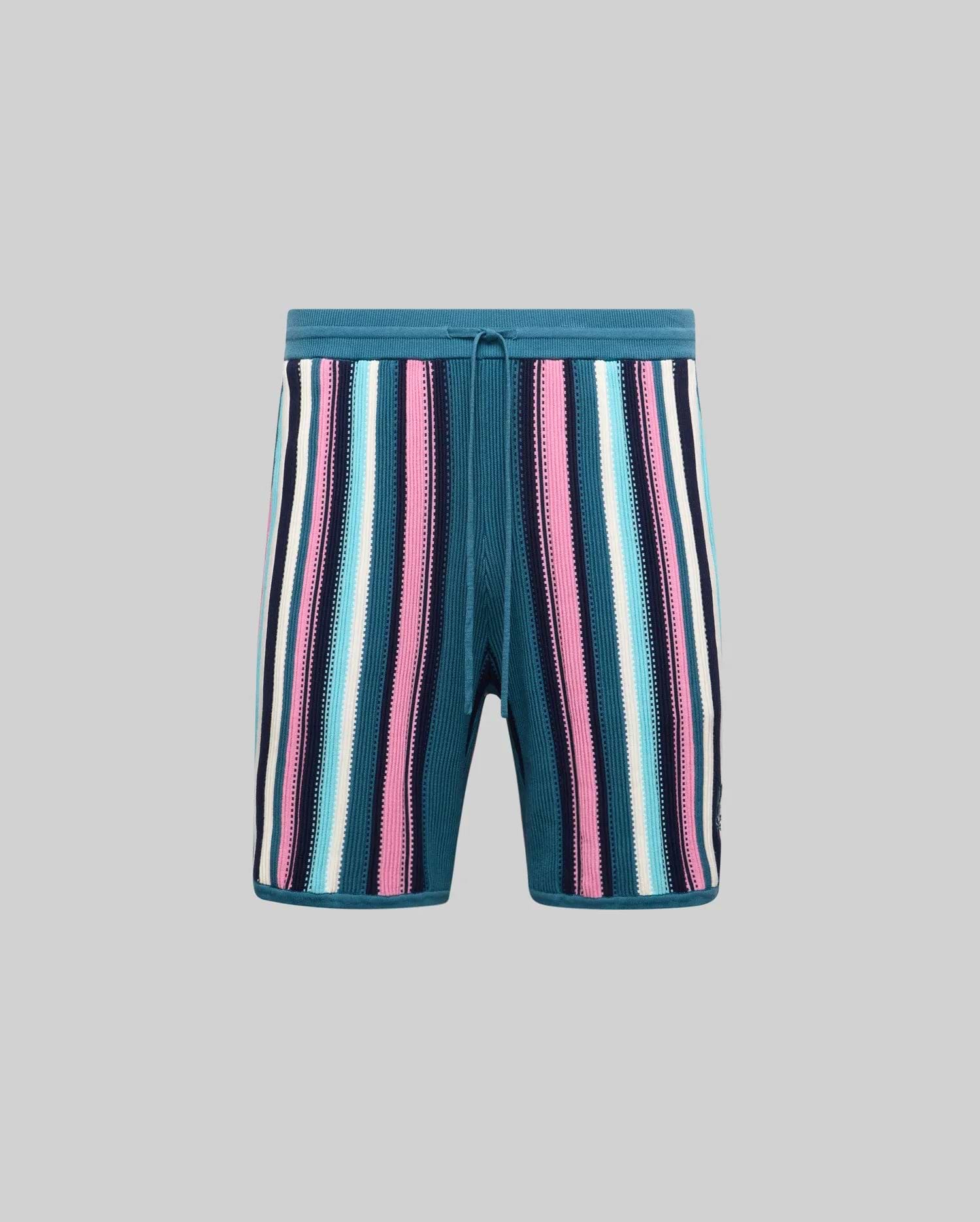 Mens Cliff Knit Short, relaxed fit, teal knit with bold vertical stripes in pink, light blue, white, and navy, featuring a drawstring waist and small embroidered Psycho Bunny skull logo.