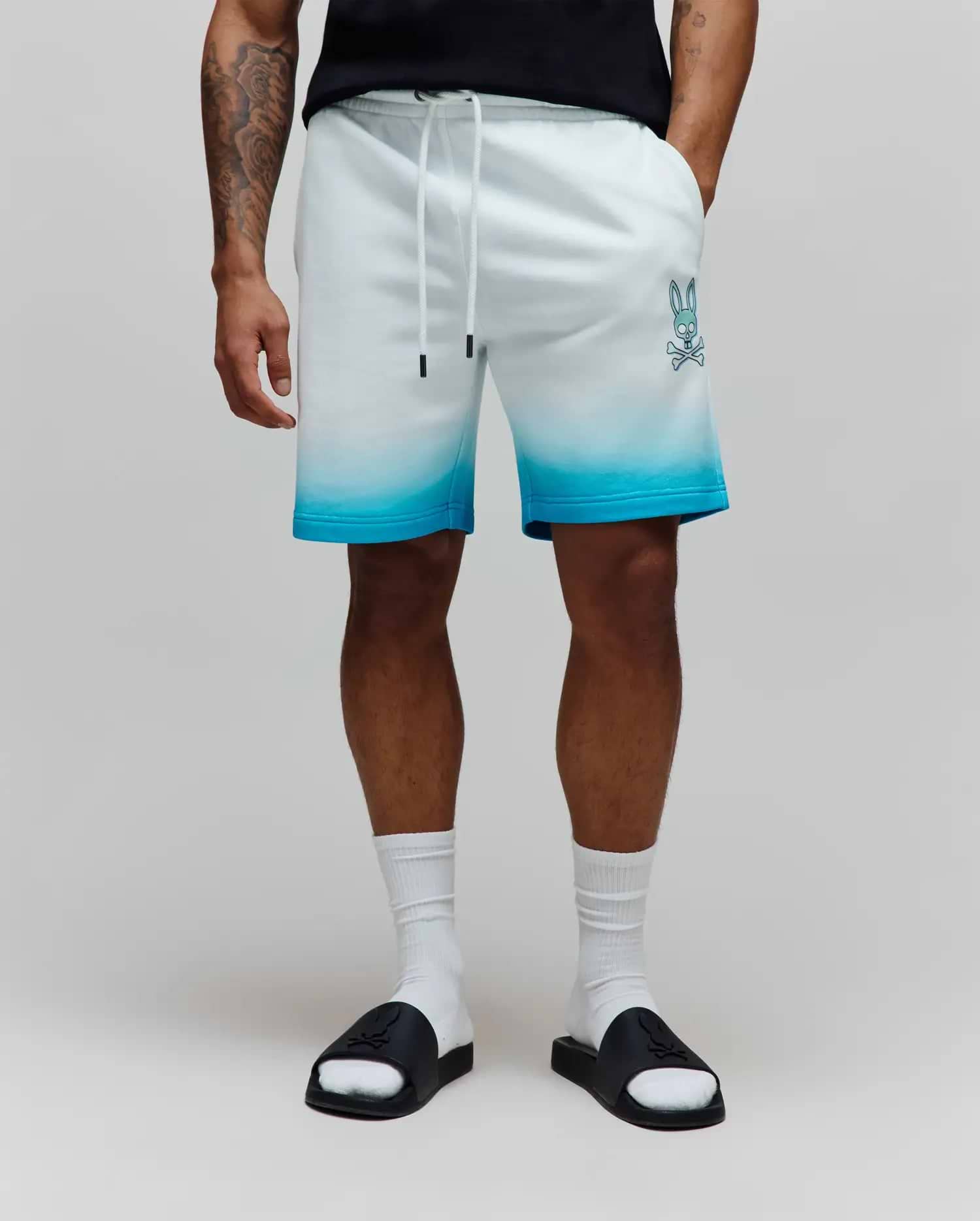 Mens Dax Sweatshort featuring a relaxed fit, soft french terry fabric, white to bright blue ombre design, and a prominent light blue Psycho Bunny skull logo on the left thigh. (1)