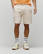 Mens Dustin Sweatshort, cream relaxed fit with all-over embossed Psycho Bunny skull and checkered pattern, textured knit fabric, drawstring waist. (1)