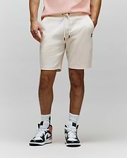 Mens Maxton Waffle Sweatshort in cream, featuring a relaxed fit, waffle knit texture, drawstring waist with black tips, and a small embroidered black Psycho Bunny skull logo on the left thigh.